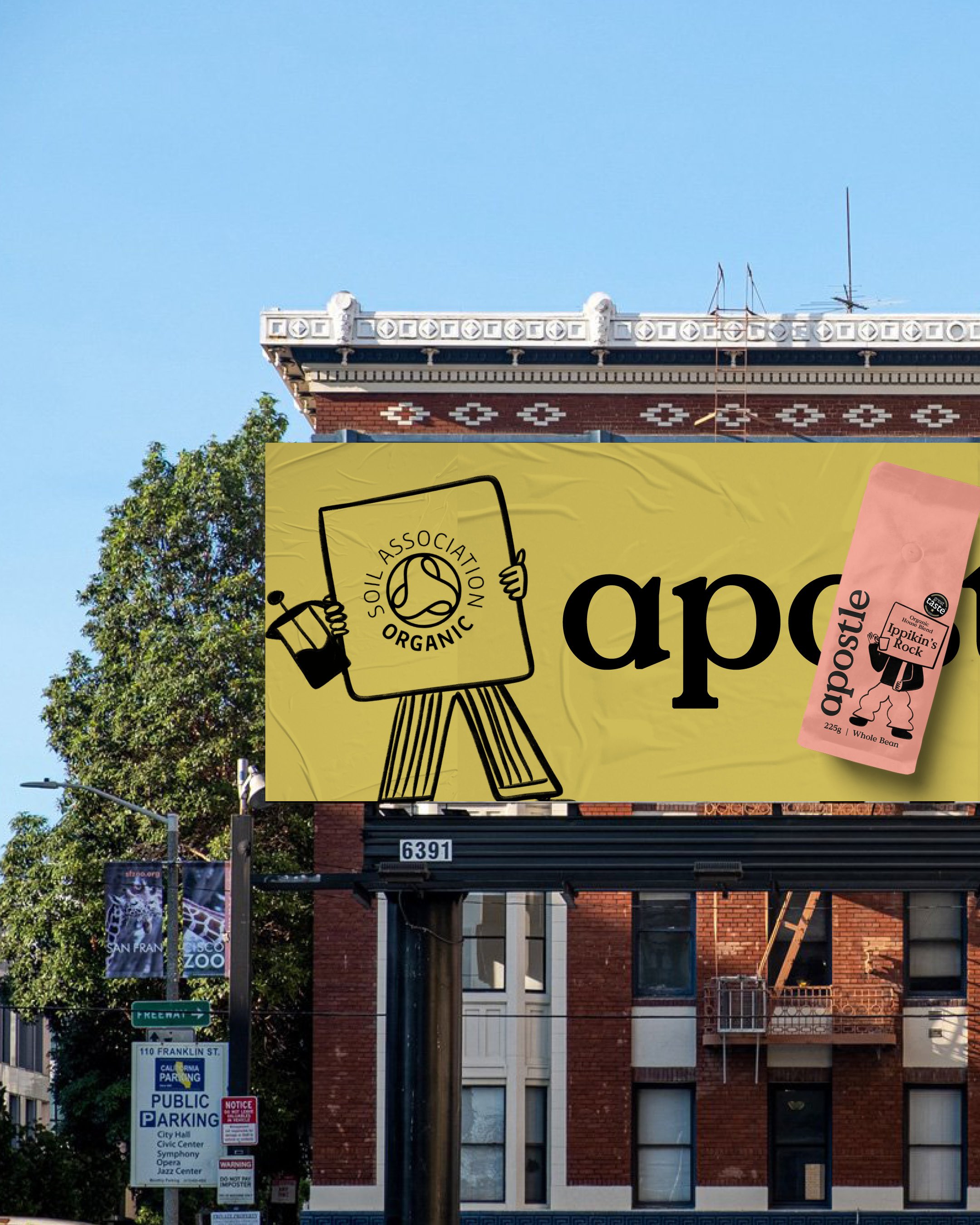 A large billboard advertising organic produce, featuring a graphic of a person holding a shopping basket with a logo that reads 'Society Association Organic.' In the background, there are street signs indicating directions for pre-natal services and 