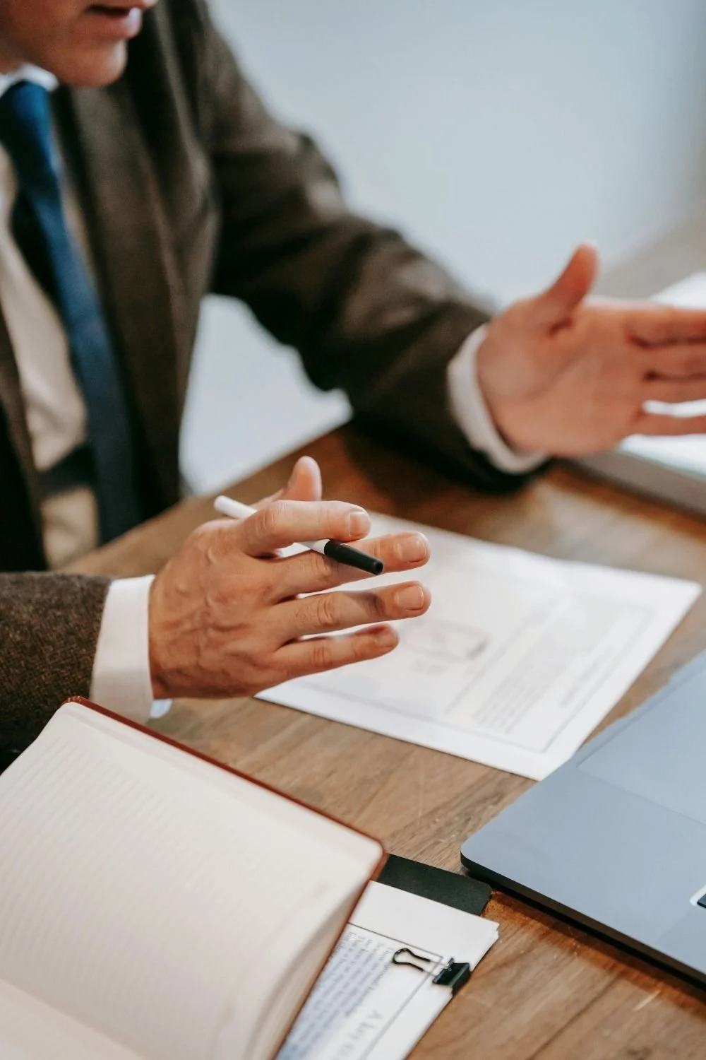 Real estate professional reviewing documents during a client meeting, representing strategic investment planning, property acquisitions, and advisory services offered by Ivy Park Properties.