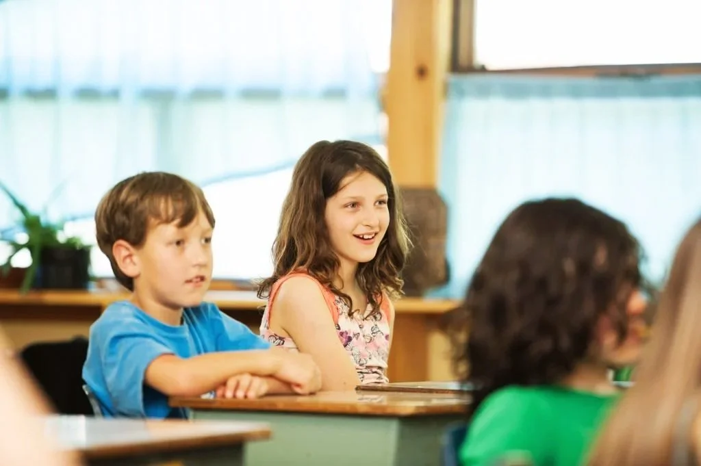 Students smiling at their school desks