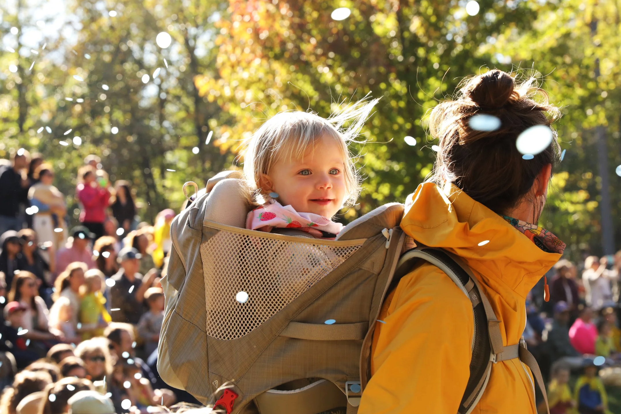 Mother and infant walking outside at a community event