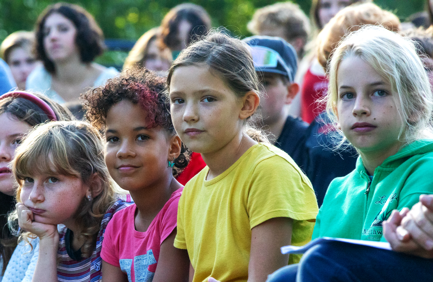 Grade school students sitting outside at a school event