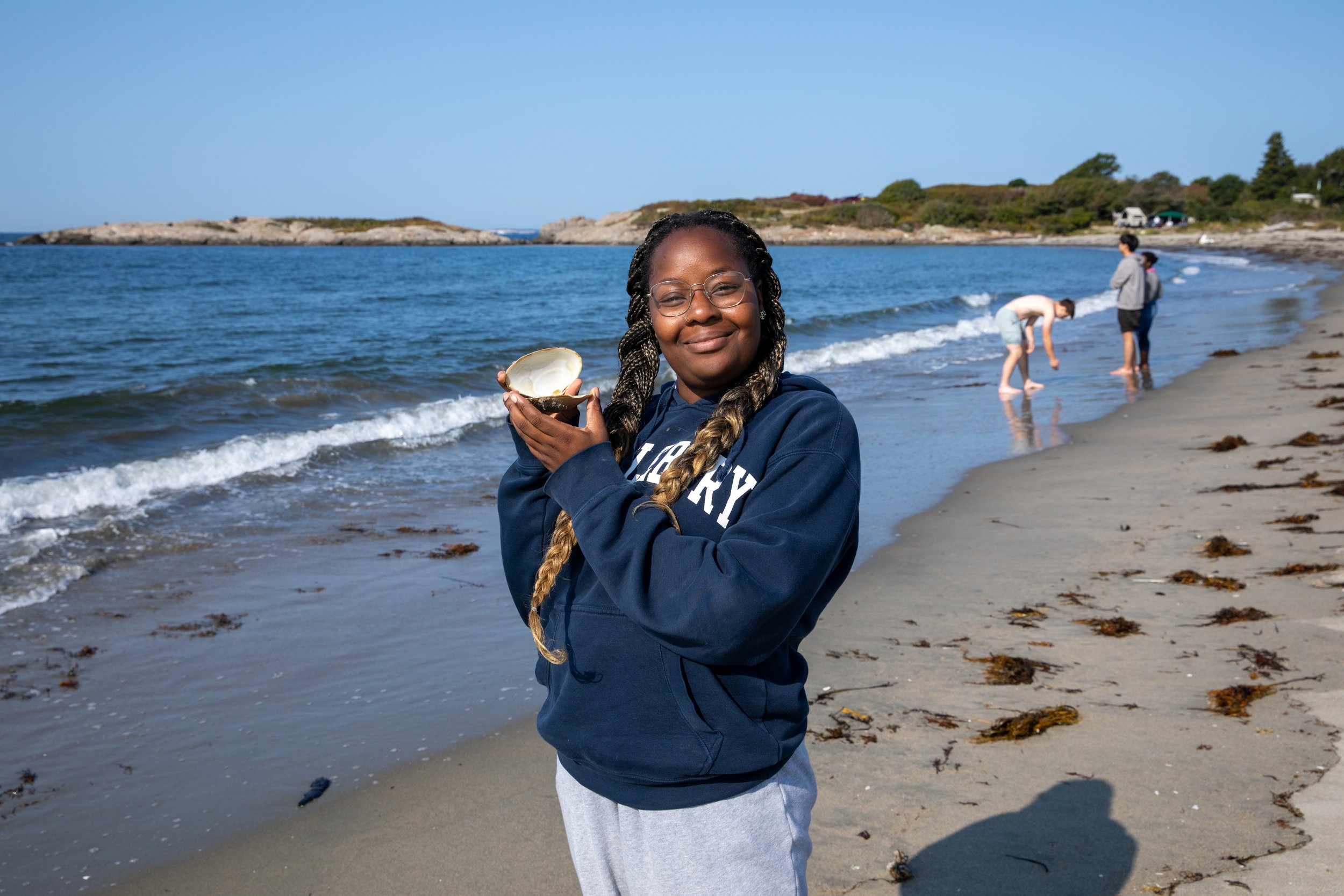 High school girl holding a shell on the Maine coast