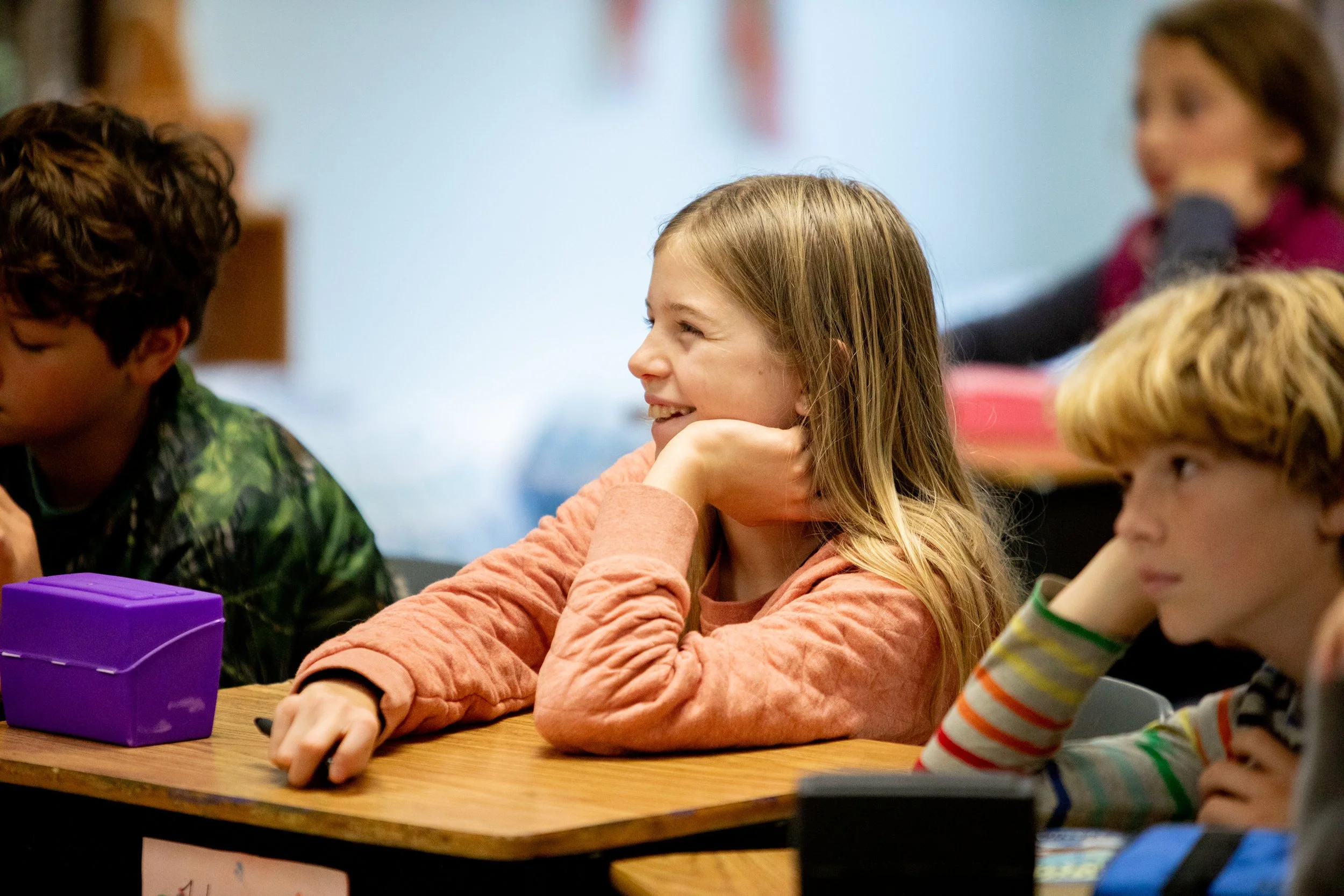 Girl laughing at her school desk