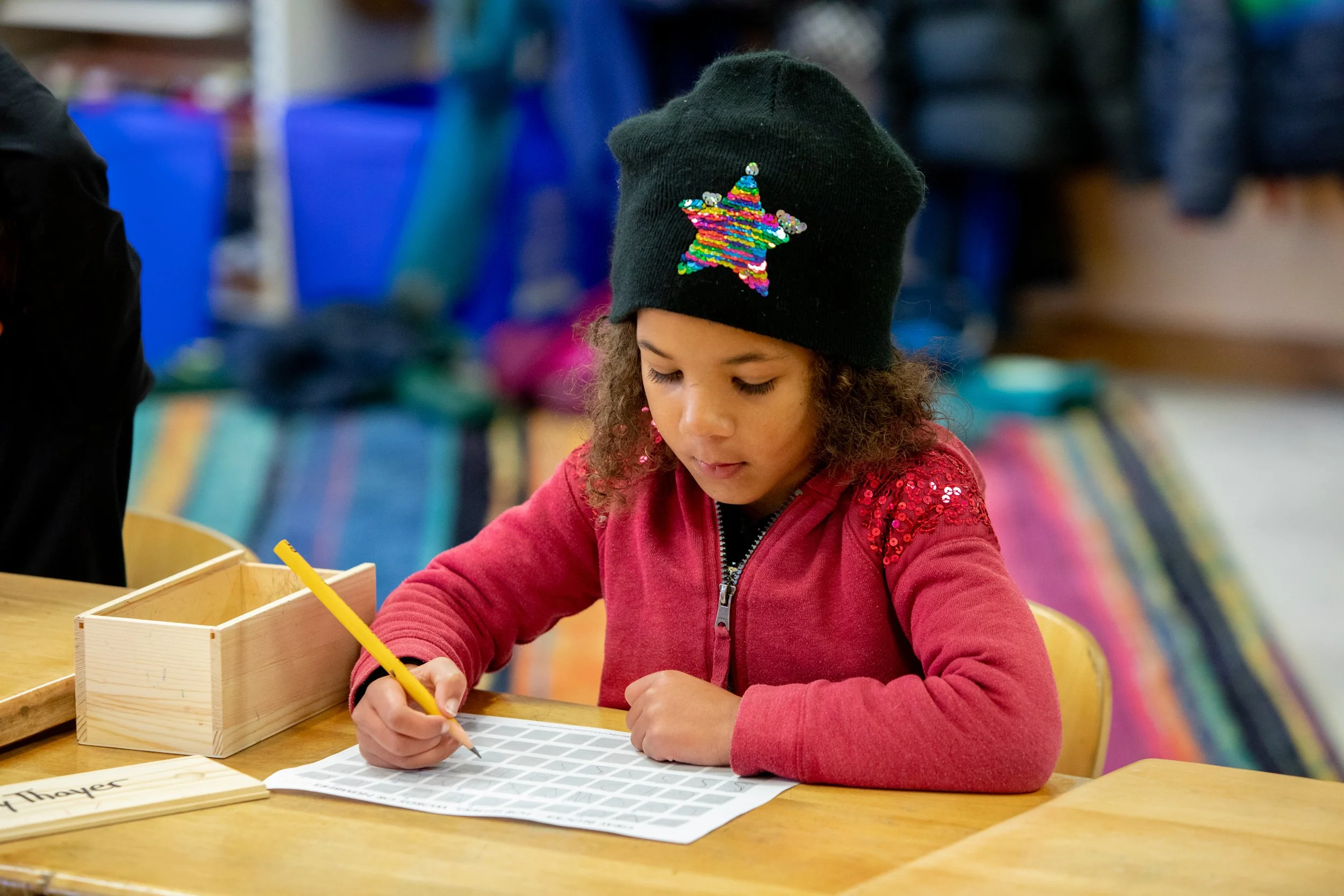 Grade school student drawing at her desk