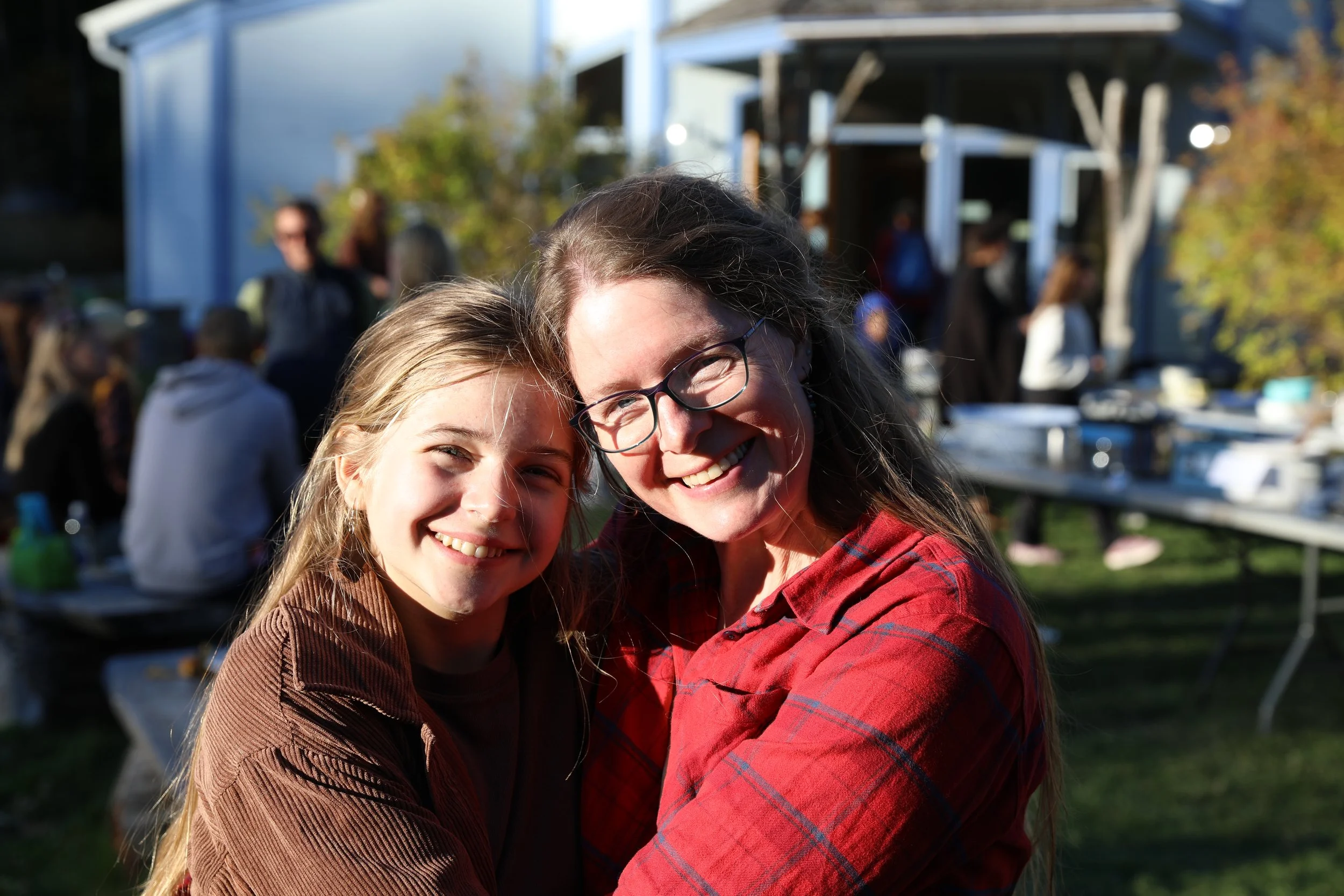 Mother and daughter smiling at community potluck
