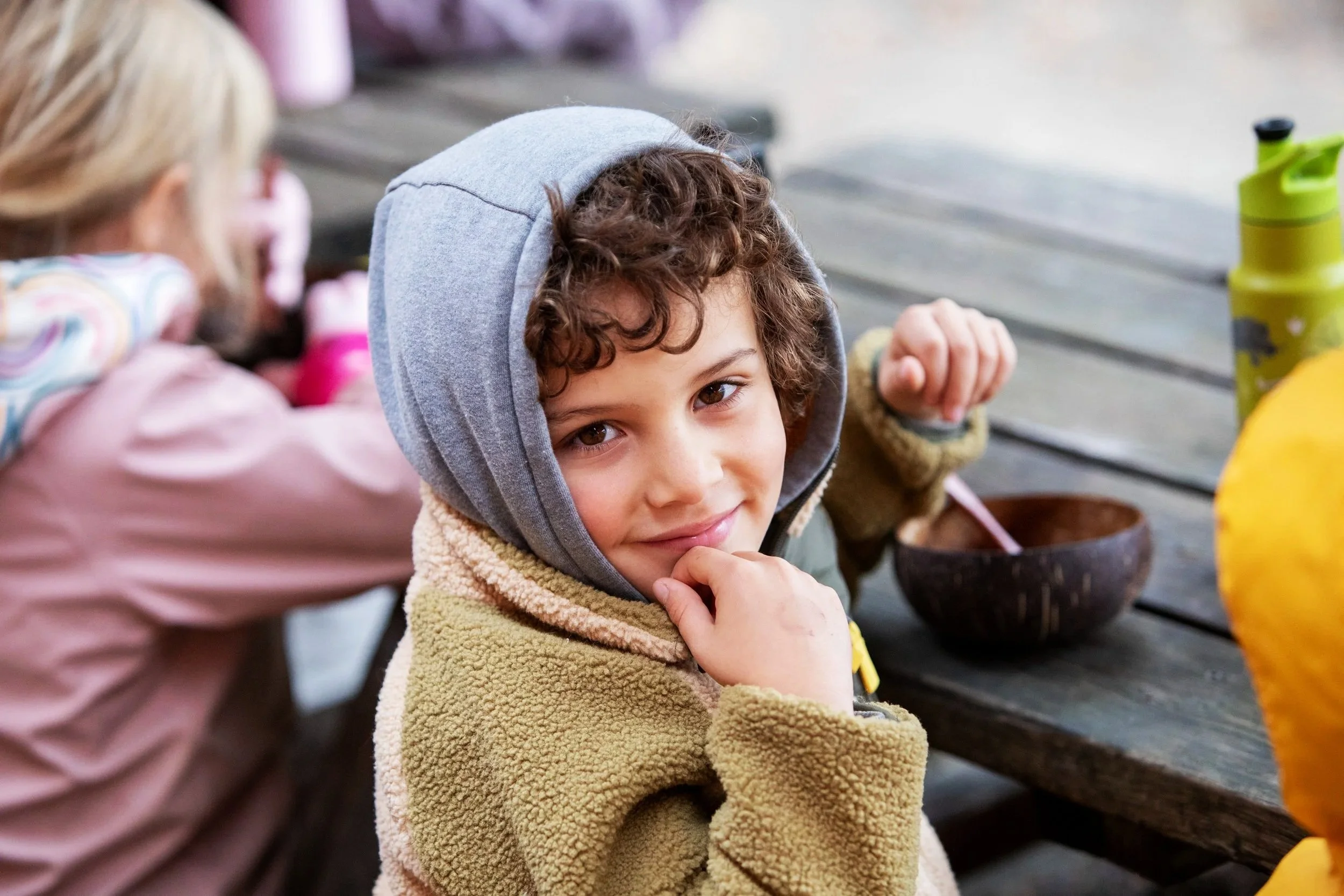 Kindergartner smiling while eating outside