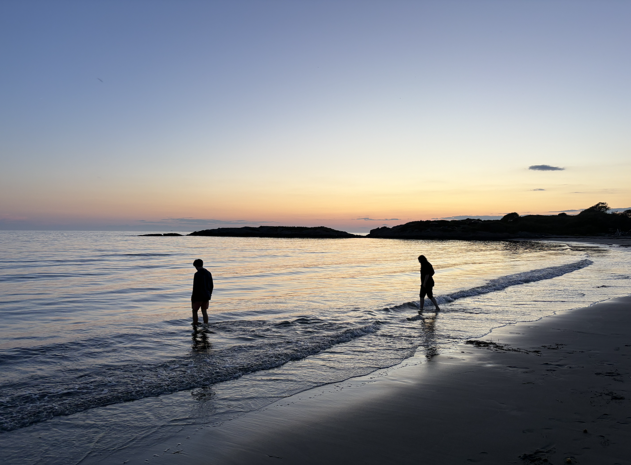 Students walking along the coast as the sun sets