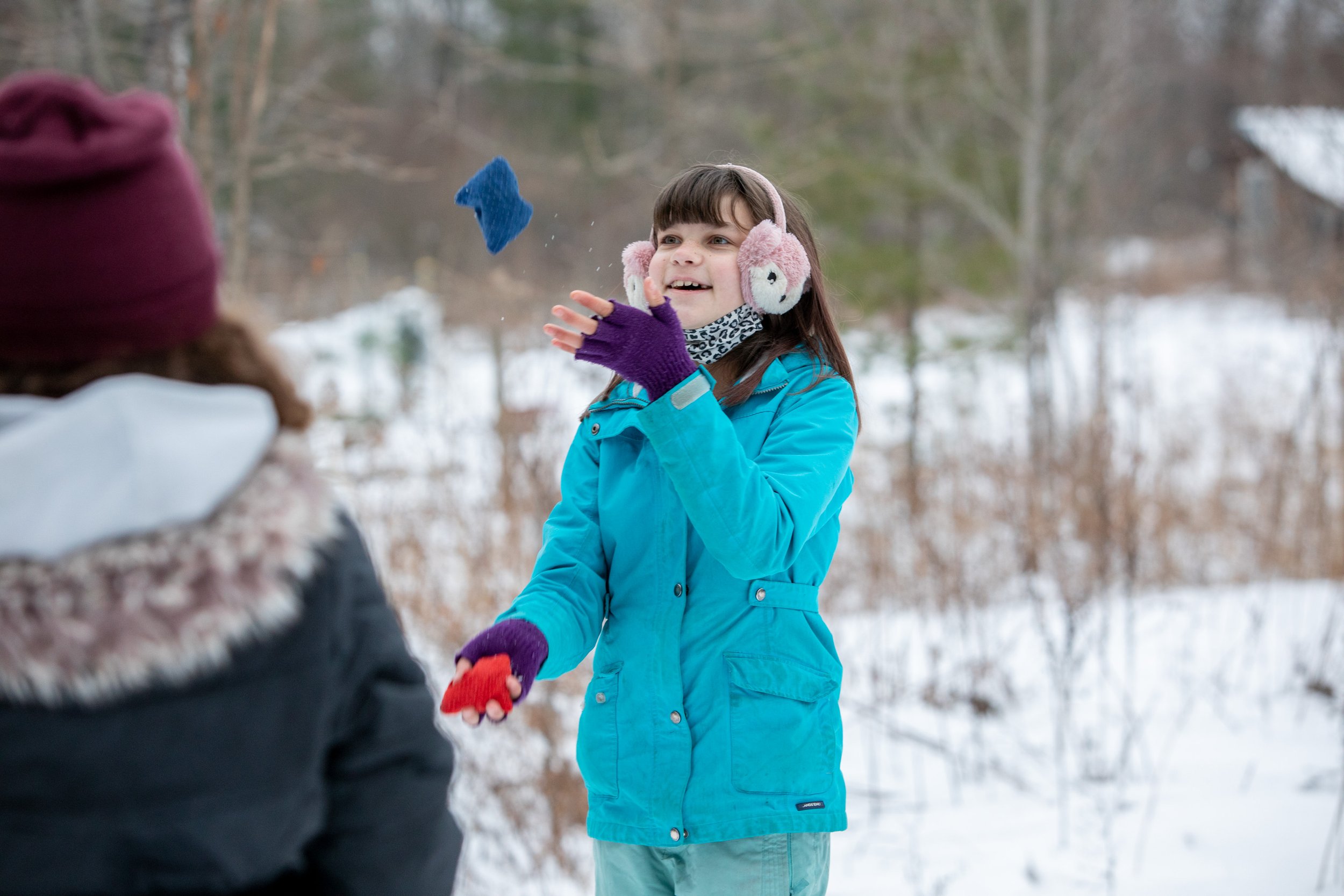 Girl outside in the snow juggling beanbags