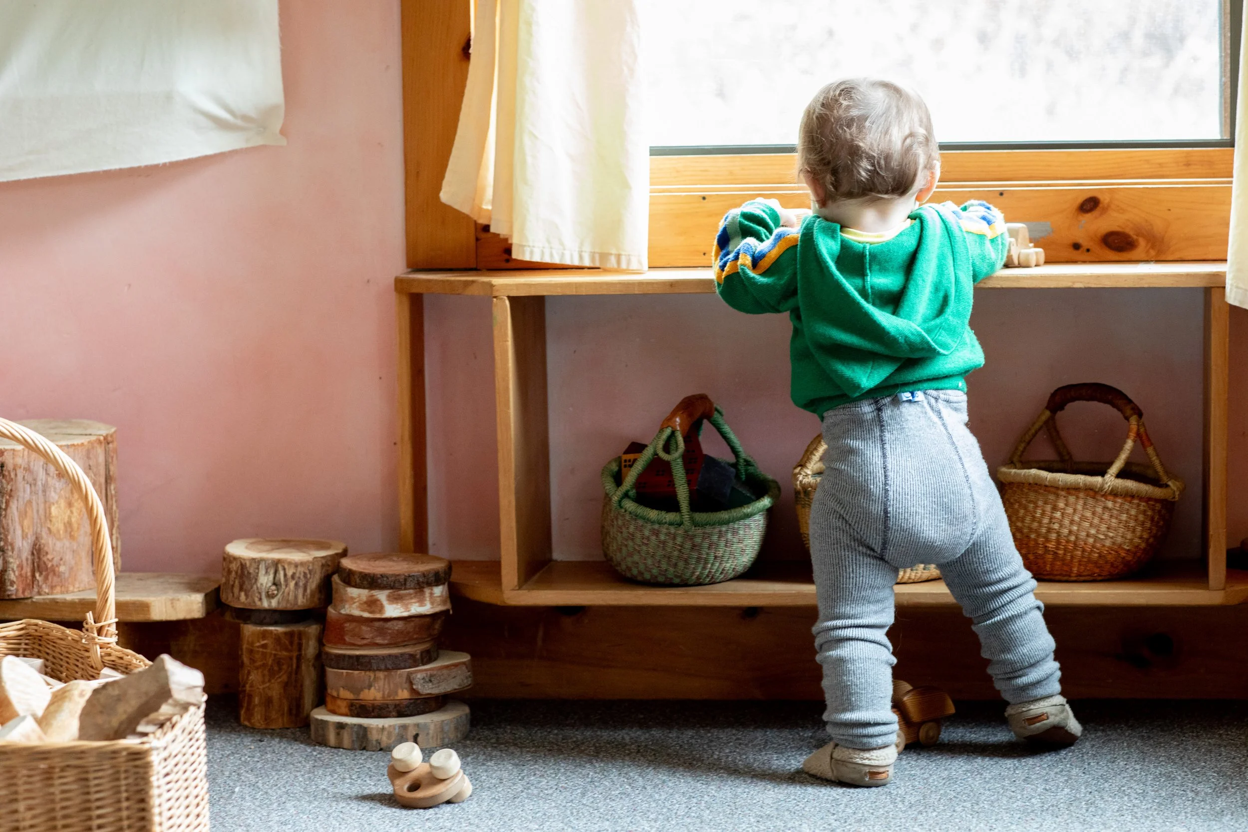 Toddler playing with wooden toys