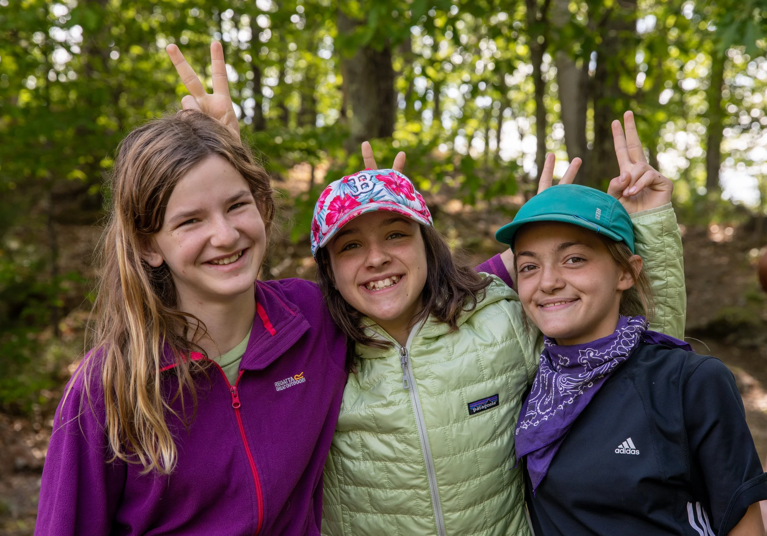 Girls smiling in the woods on a class trip