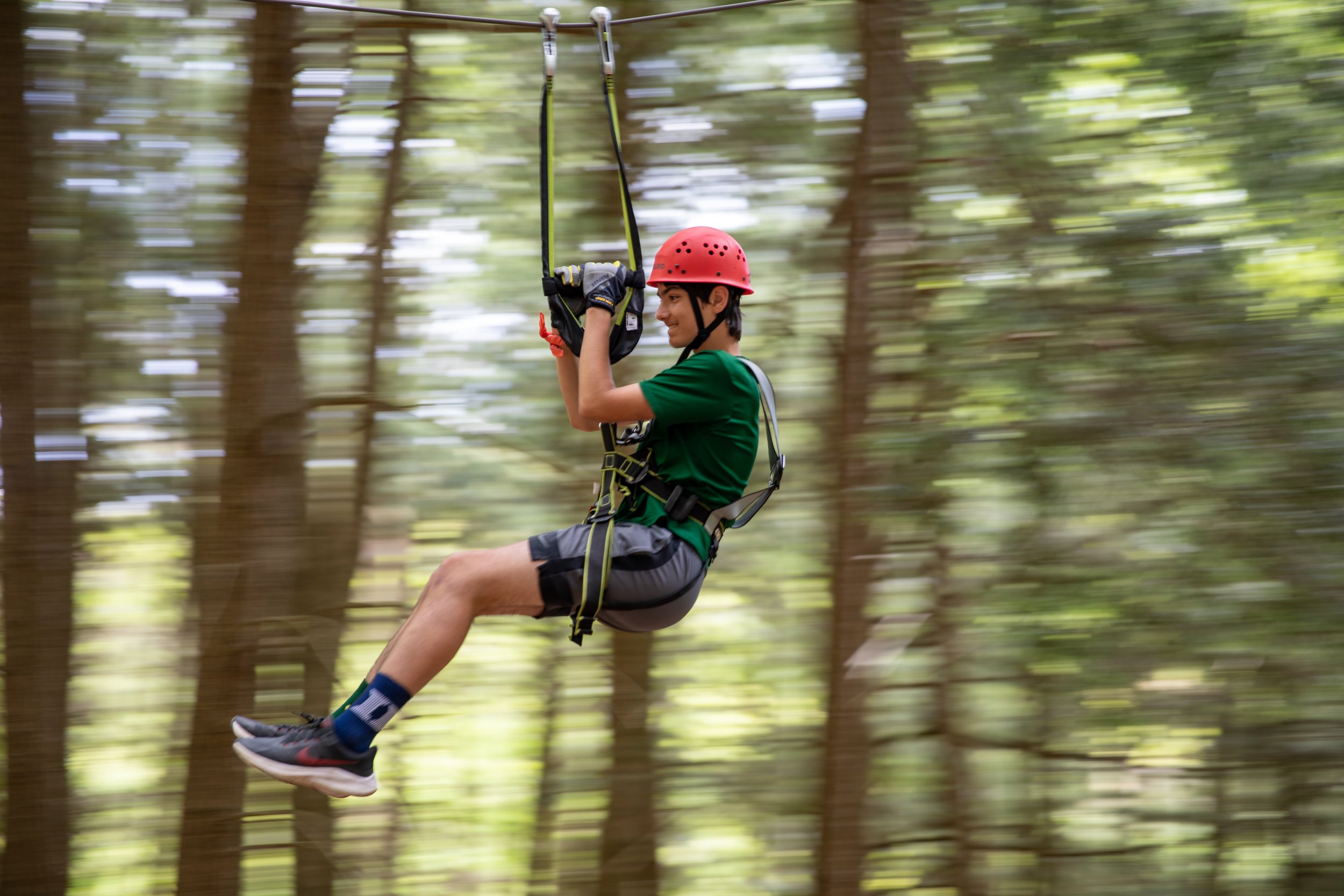 Middle school student on a zipline in the woods