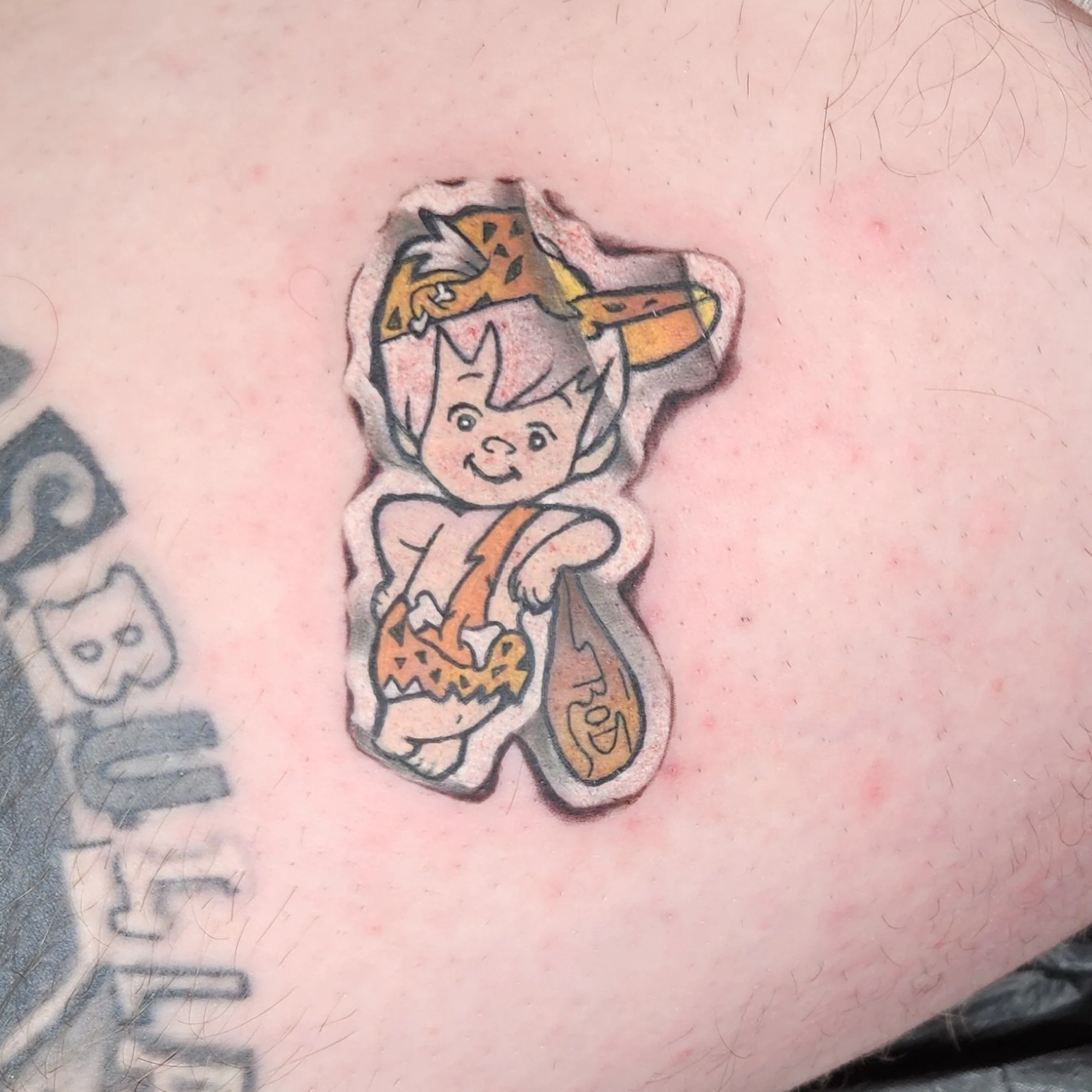 A tattoo of a cartoon bambam