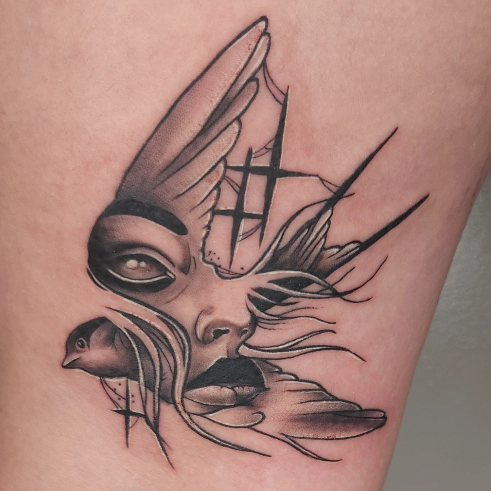 Close-up of a tattoo depicting a praying hand, with detailed shading and black outline, on skin.