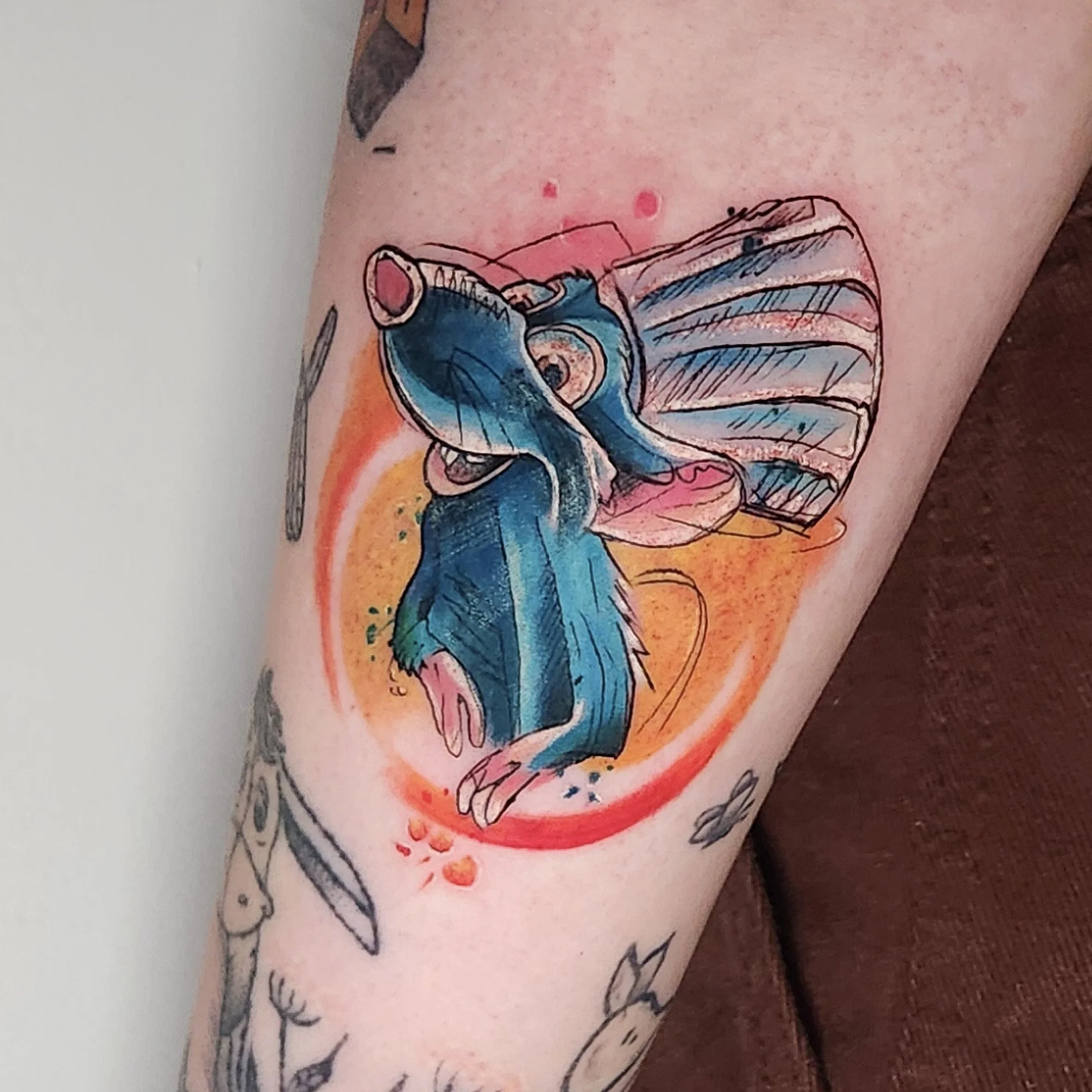 Tattoo of a colourful rat from ratatouille.