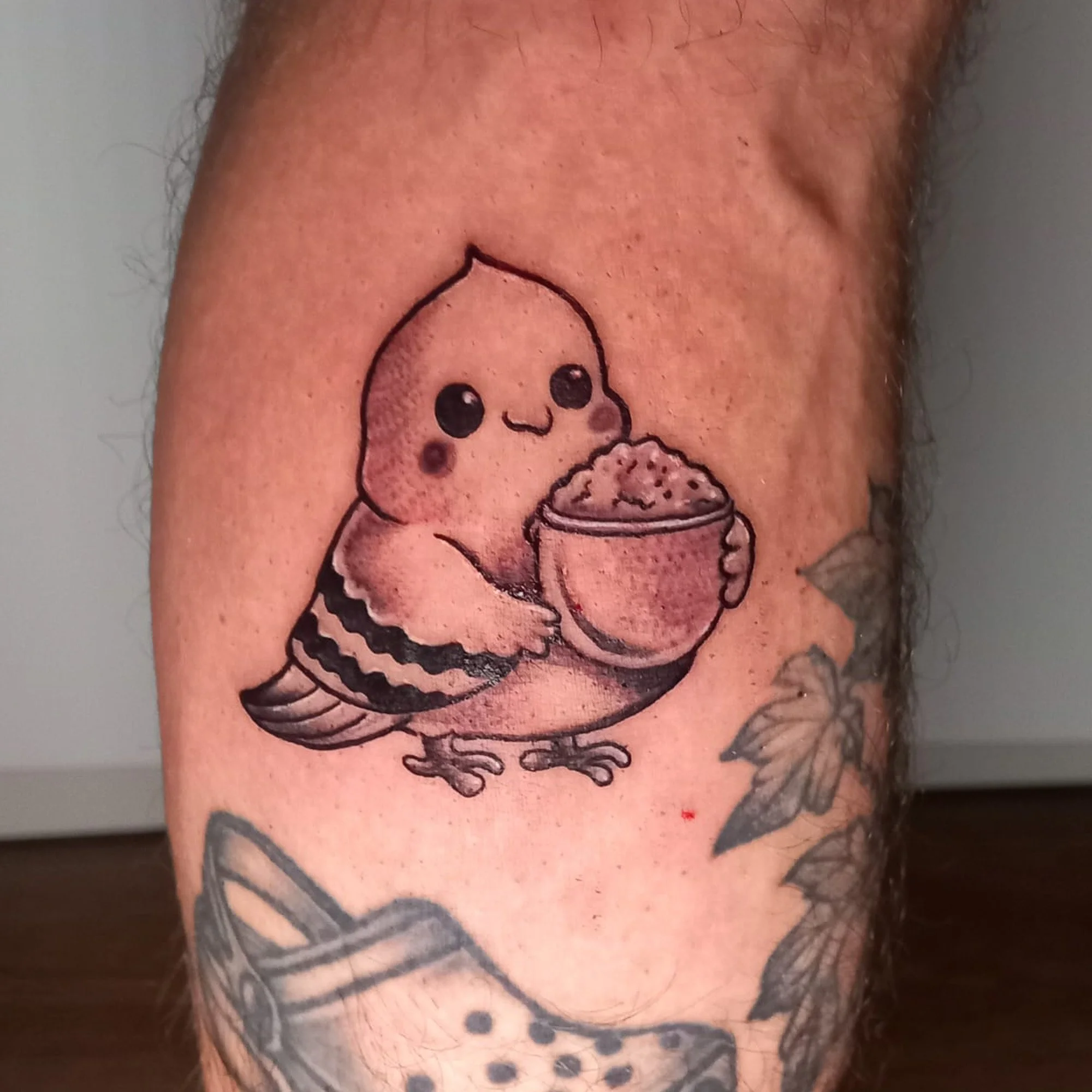 Tattoo on skin of a cartoon pig holding a slice of pizza.