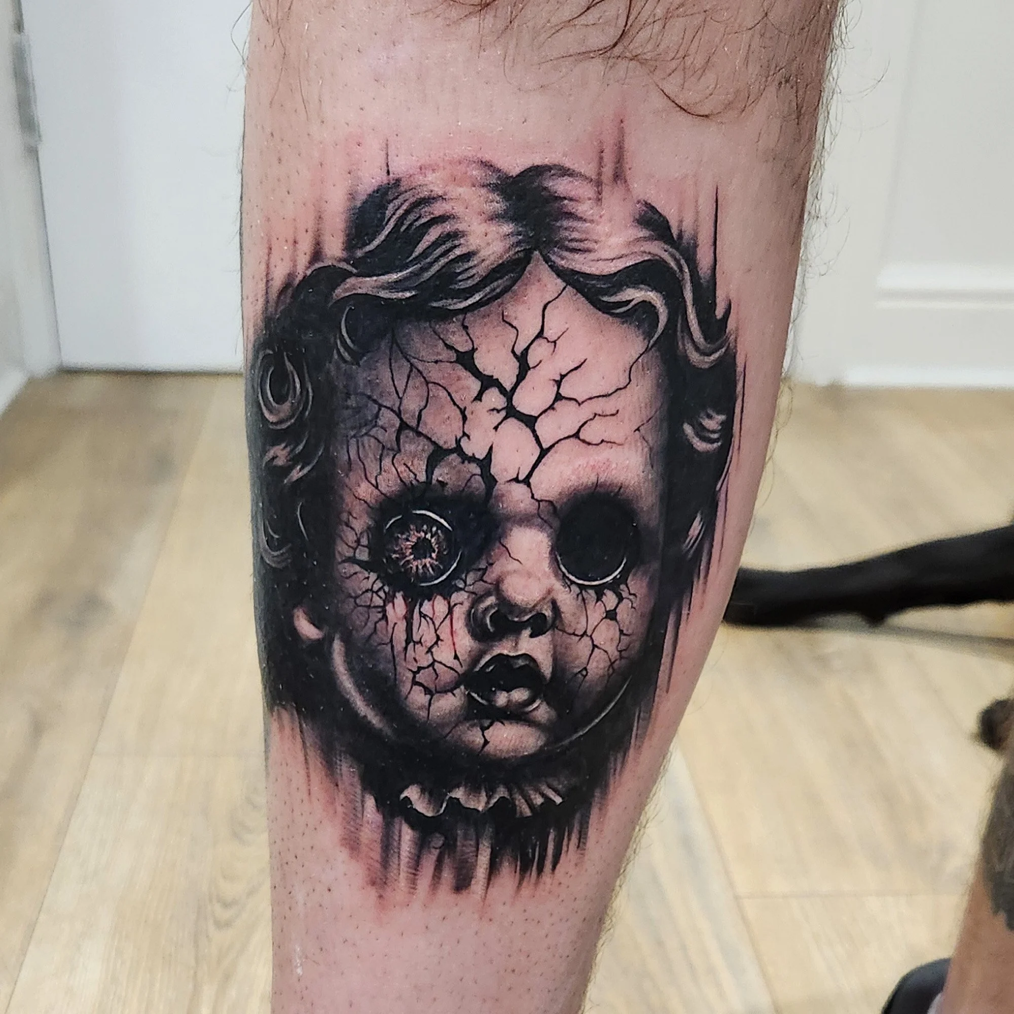 Black and grey, realistic horror smashed china doll tattoo