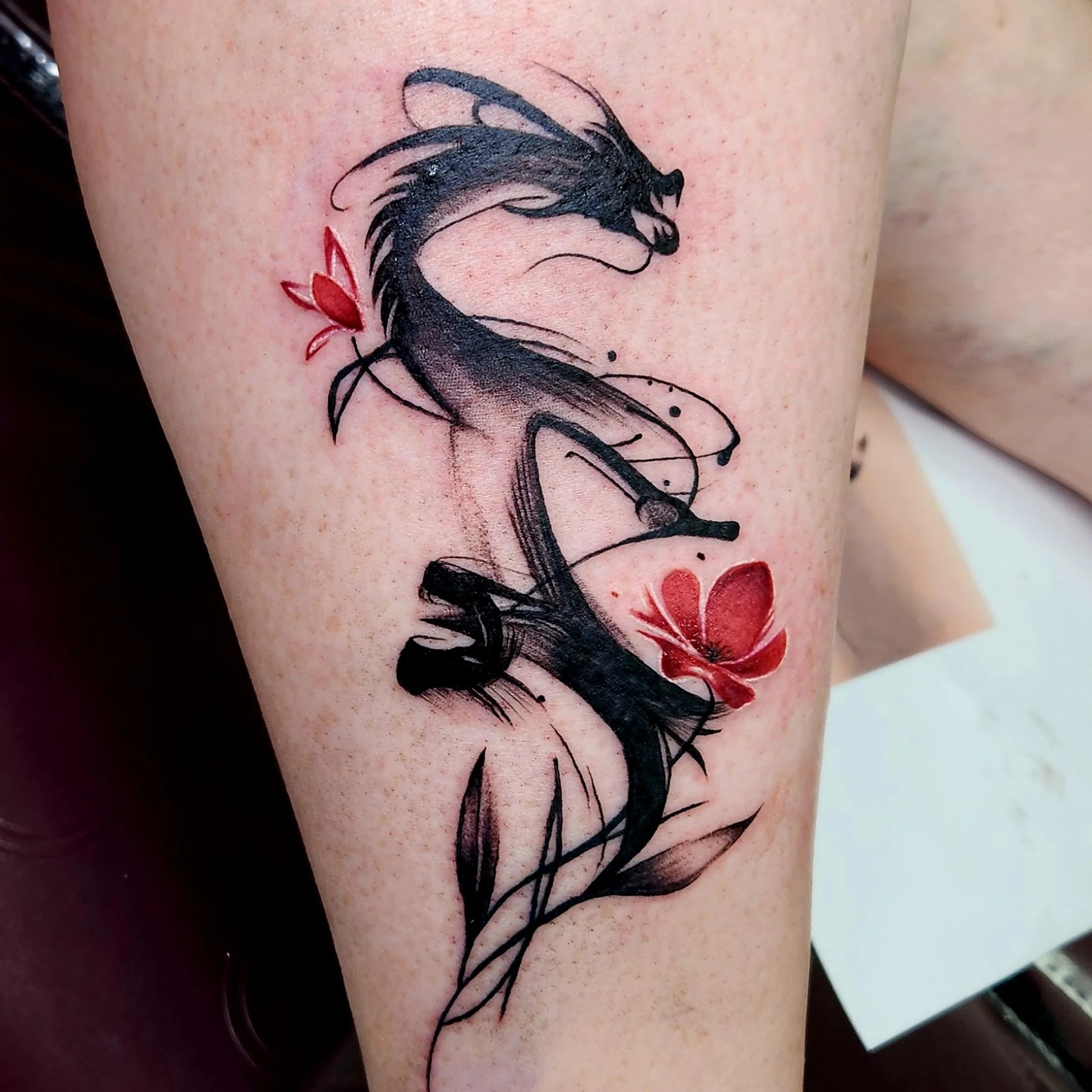 Tattoo of a black and grey dragon