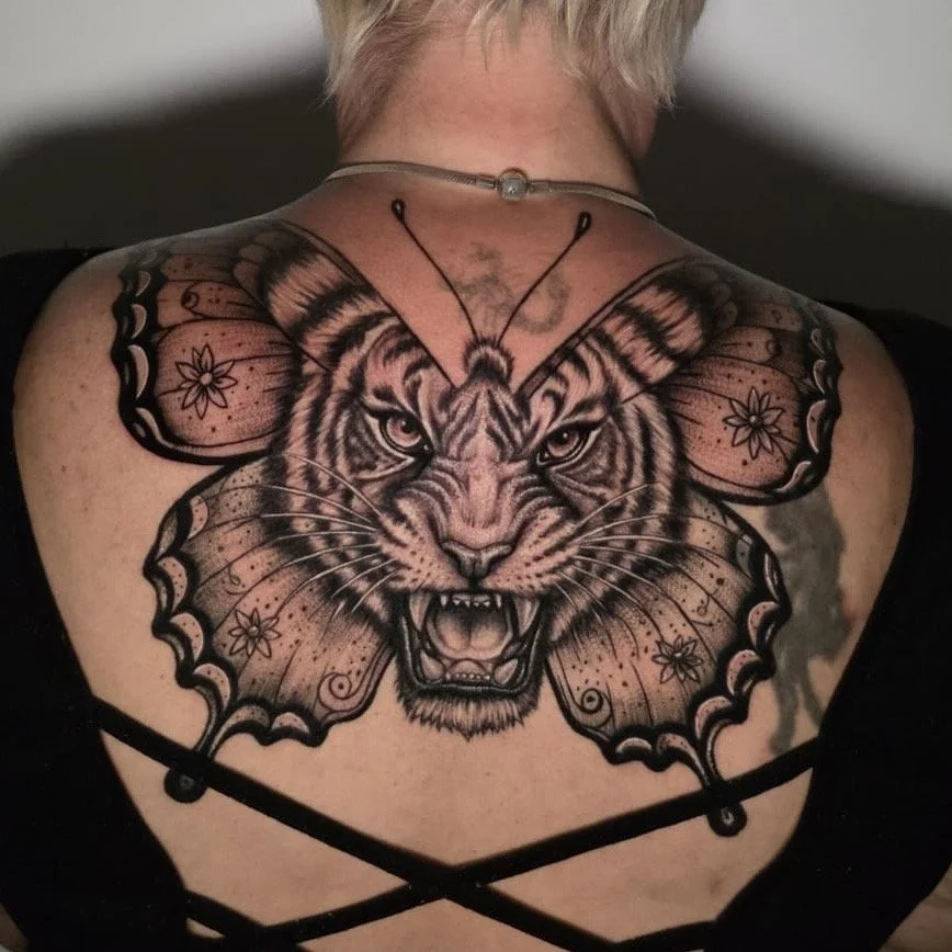 Large tattoo of butterfly on back with tiger face.