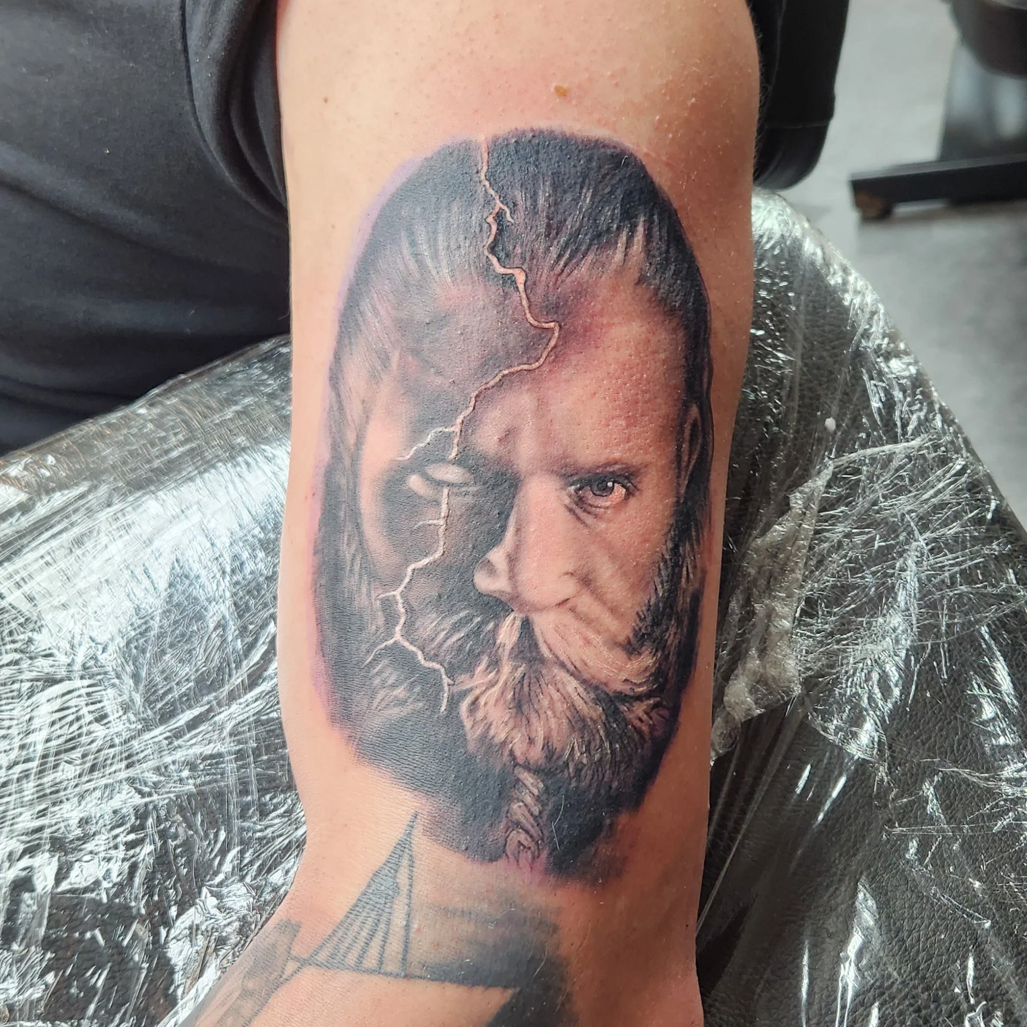 Black and grey realistic portrait of Odin tattoo