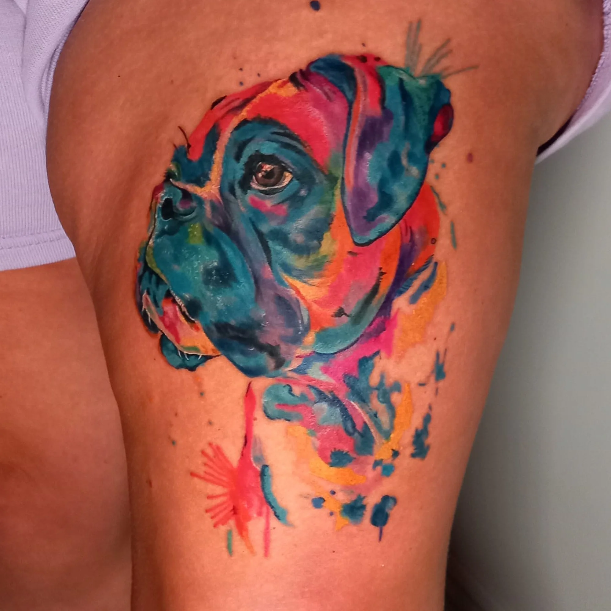 Colorful dog tattoo on a person's skin.