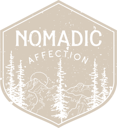 A photography logo in the shape of a patch with the word 'Nomadic Affection' and an image of pine trees, resembling a wilderness or outdoor adventure logo.