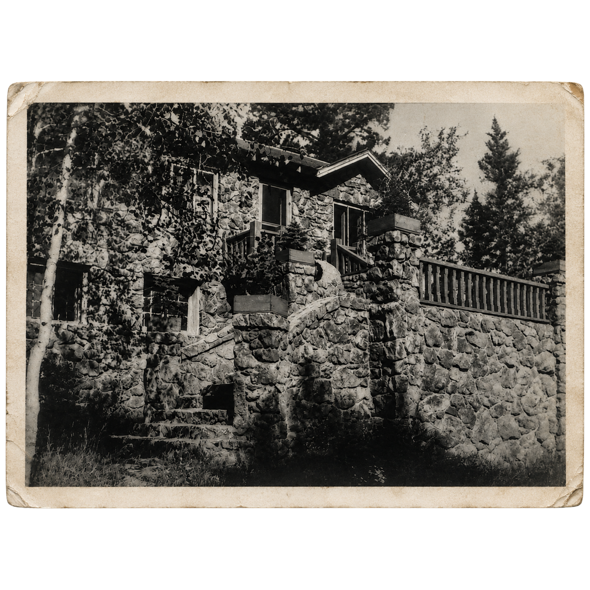A black-and-white photo of Meadow Creek Lodge from the 1930's with stone walls, surrounded by trees.