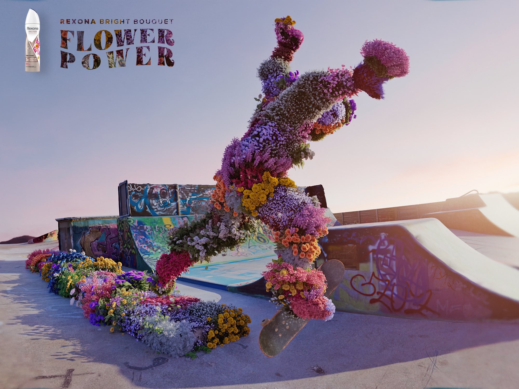 Scultura di un cavallo coperta di fiori colorati, posta sopra un skateboard decorato con graffiti, circondata da composizioni floreali, al tramonto.