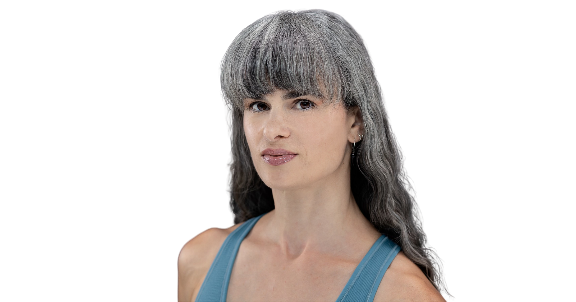 Portrait of a woman with long gray hair and light skin, wearing a teal athletic top, against a black background.