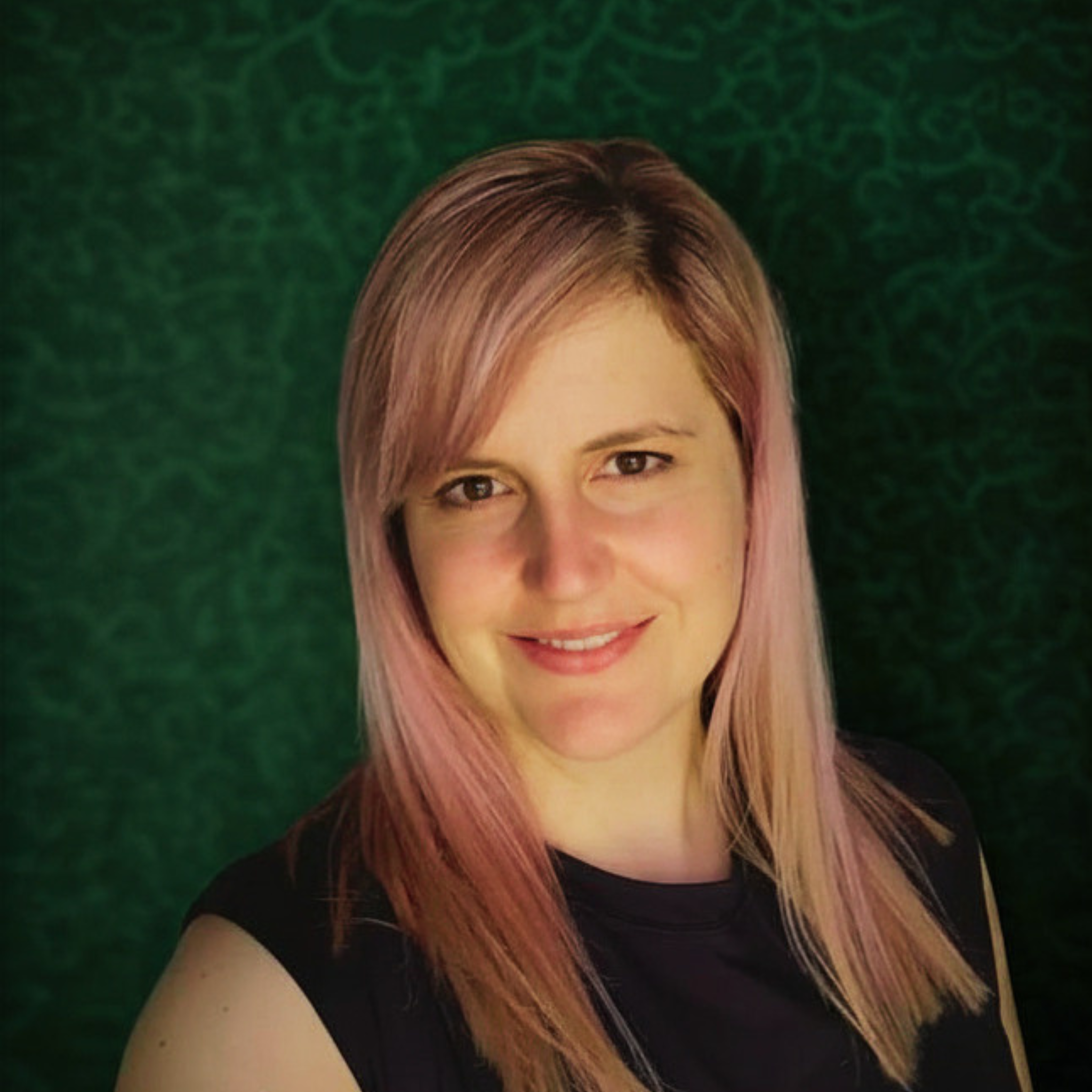 A woman with straight hair dyed in shades of pink and brown, smiling, against a green textured background.