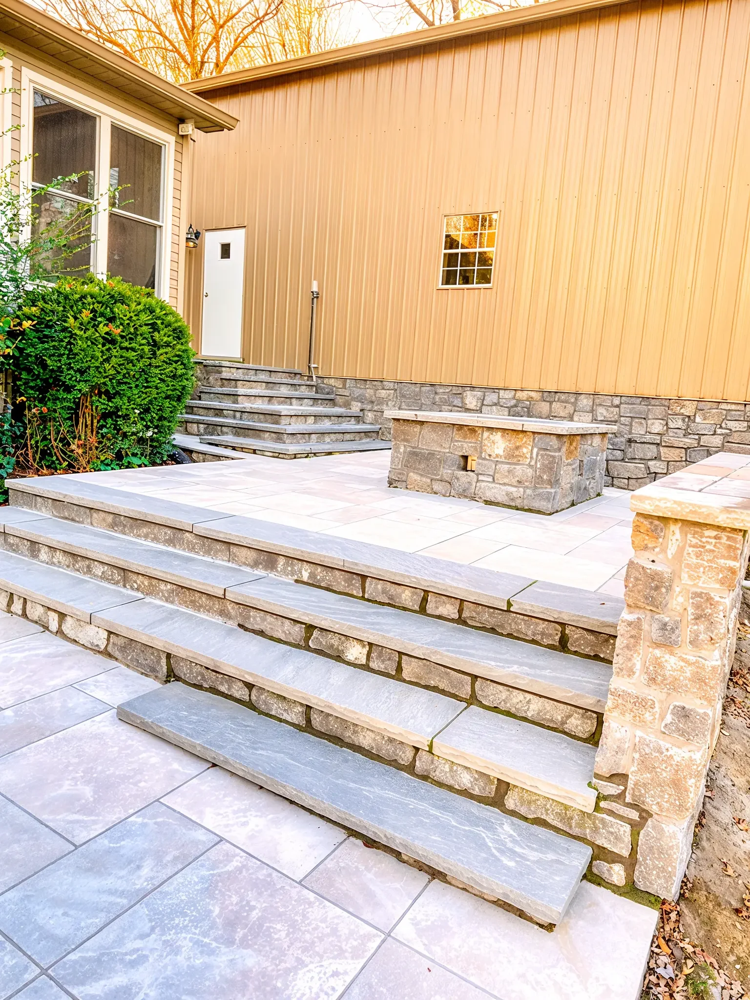 elevated-natural-stone-tile-patio-steps-outdoor-seating.webp