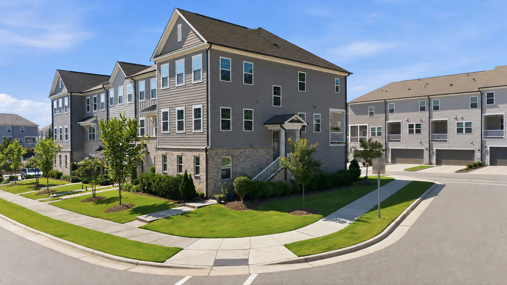 Modern townhomes in a Cary, North Carolina neighborhood with sidewalks, landscaped lawns, garages, and multi-level homes.