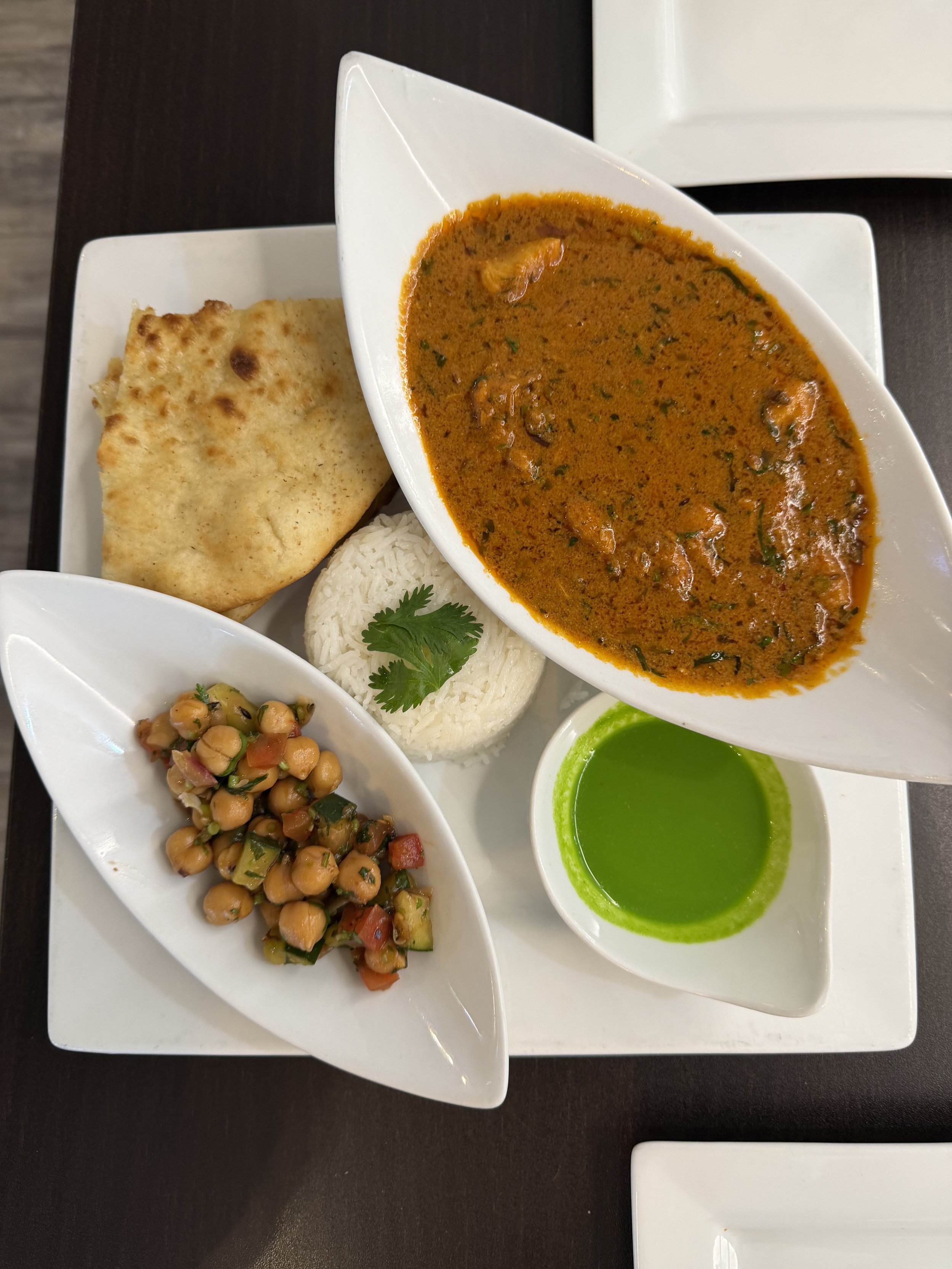 Indian meal from Cilantro Indian Cafe near Cary, North Carolina, featuring curry, rice, naan, chickpea salad, and green chutney.