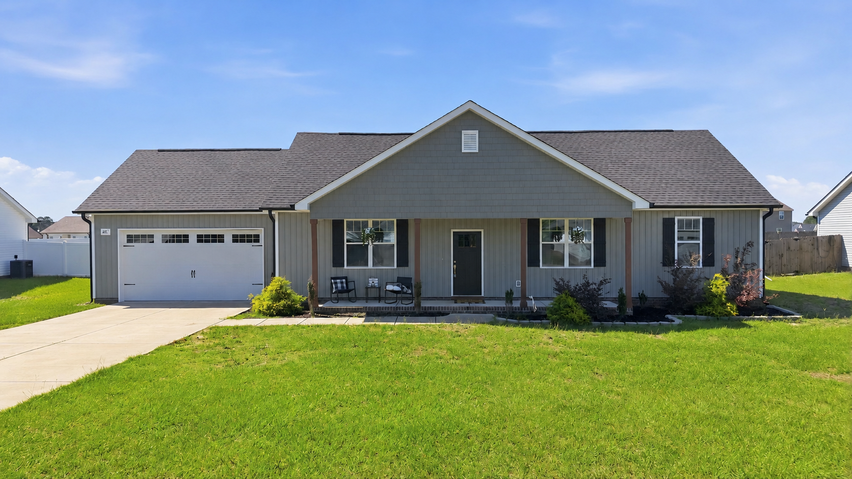 Newer single-story home with a covered front porch, attached garage, and large lawn in Bailey, North Carolina.