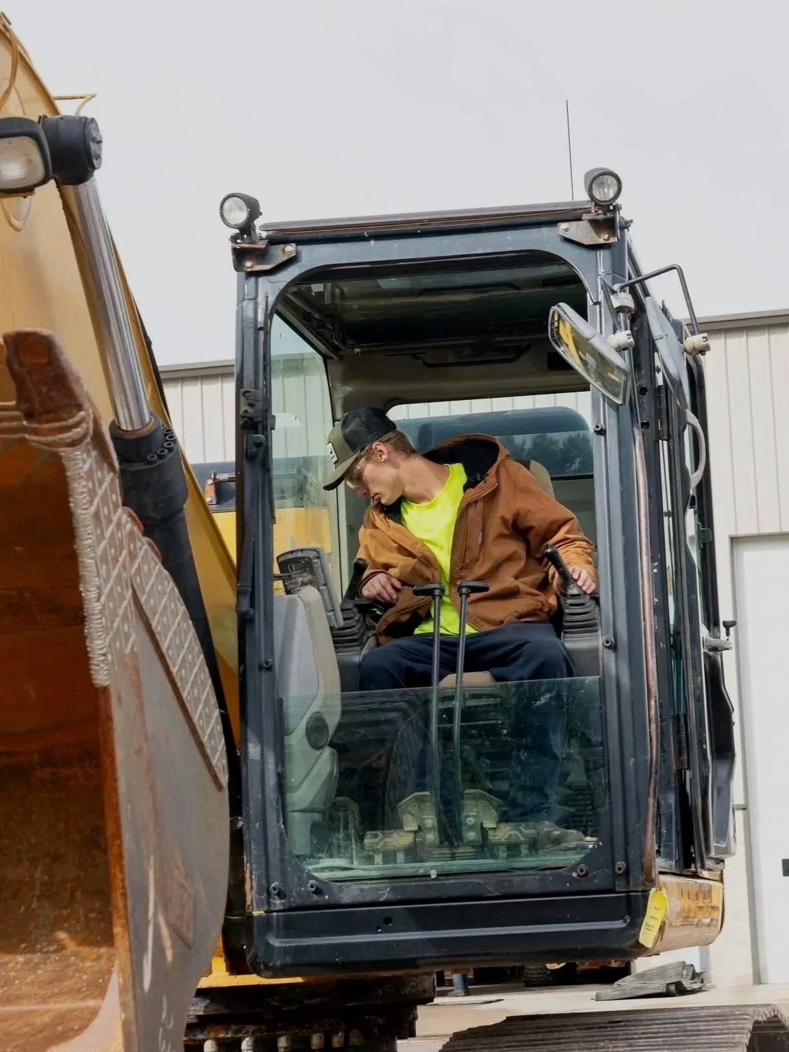 Young man in a large excavator, landscaping, landscape design.