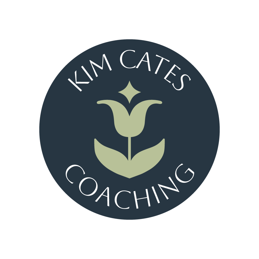 A circular logo with a dark background featuring a stylized tulip in the center. The text "Kim Cates Coaching" is curved around the top and bottom of the circle.