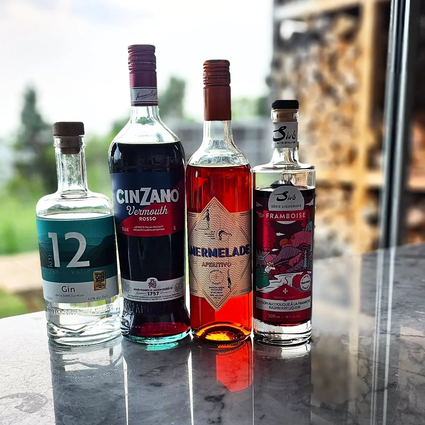 Homemade "Charlevoix Negroni" with a splash of Framboise.

Bottle Lineup:

+ Gin Km 12 &ndash; A popular Canadian craft dry gin produced by Distillerie du Fjord in Quebec, easily recognized by its distinctive teal label and large white numb