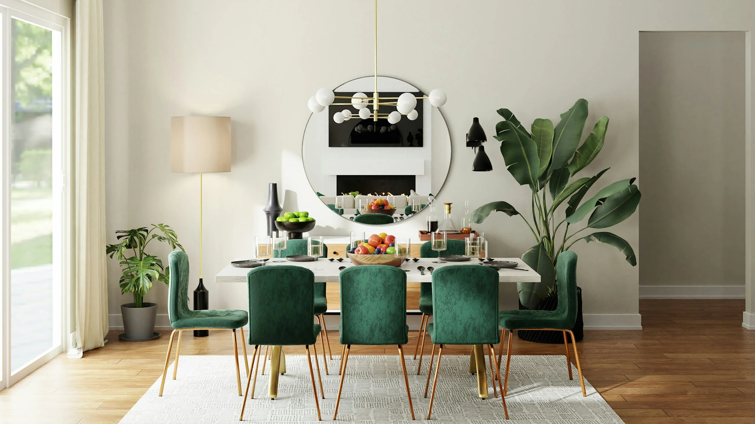 A dining room with a white table set with black plates and glasses, surrounded by eight green velvet chairs. A large round mirror hangs on the wall behind the table, with a modern chandelier above it. The room has large windows with light curtains, green indoor plants, and a wooden floor with a white patterned rug.