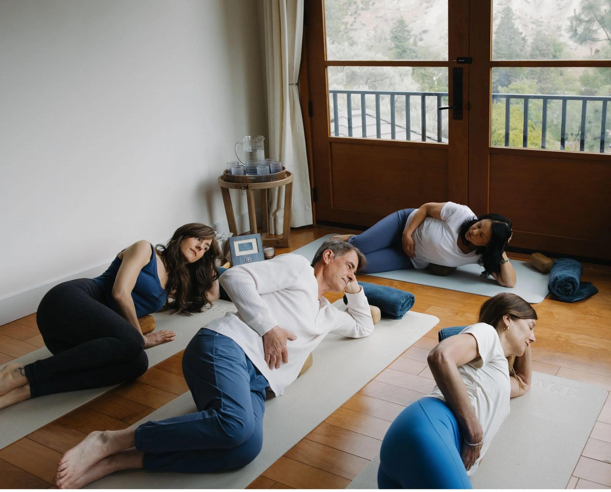 Small group practicing Block Therapy positions with yoga mats and wood blocks in the Okanagan Valley.