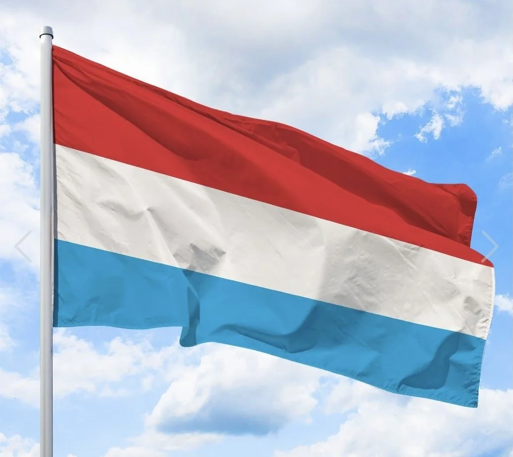 Drapeau national des Pays-Bas avec bandes horizontales rouge, blanche et bleue, volant dans le ciel avec des nuages.
