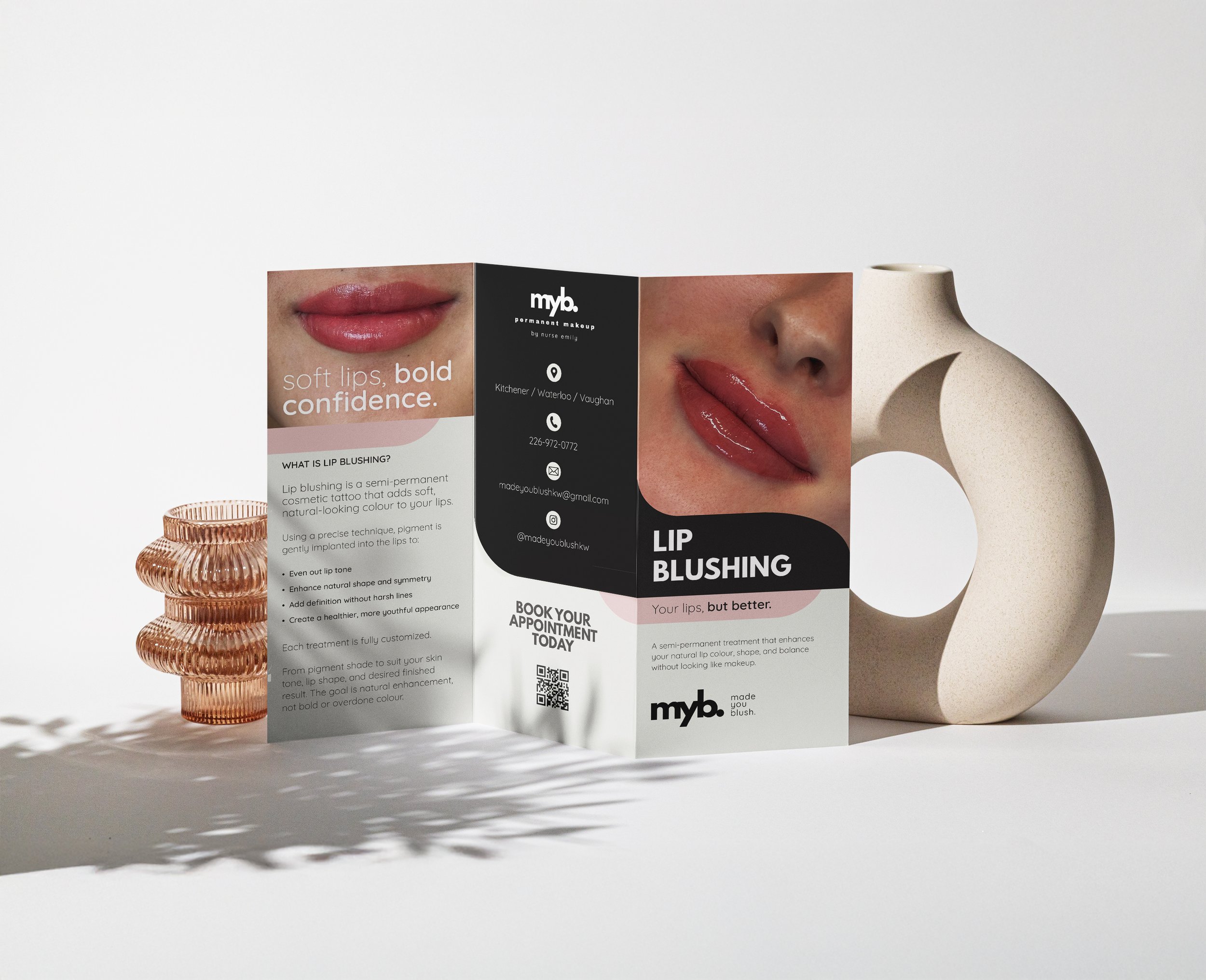 Brochure about lip blushing treatments featuring images of lips and contact information, placed on a white surface with a large decorative vase nearby.