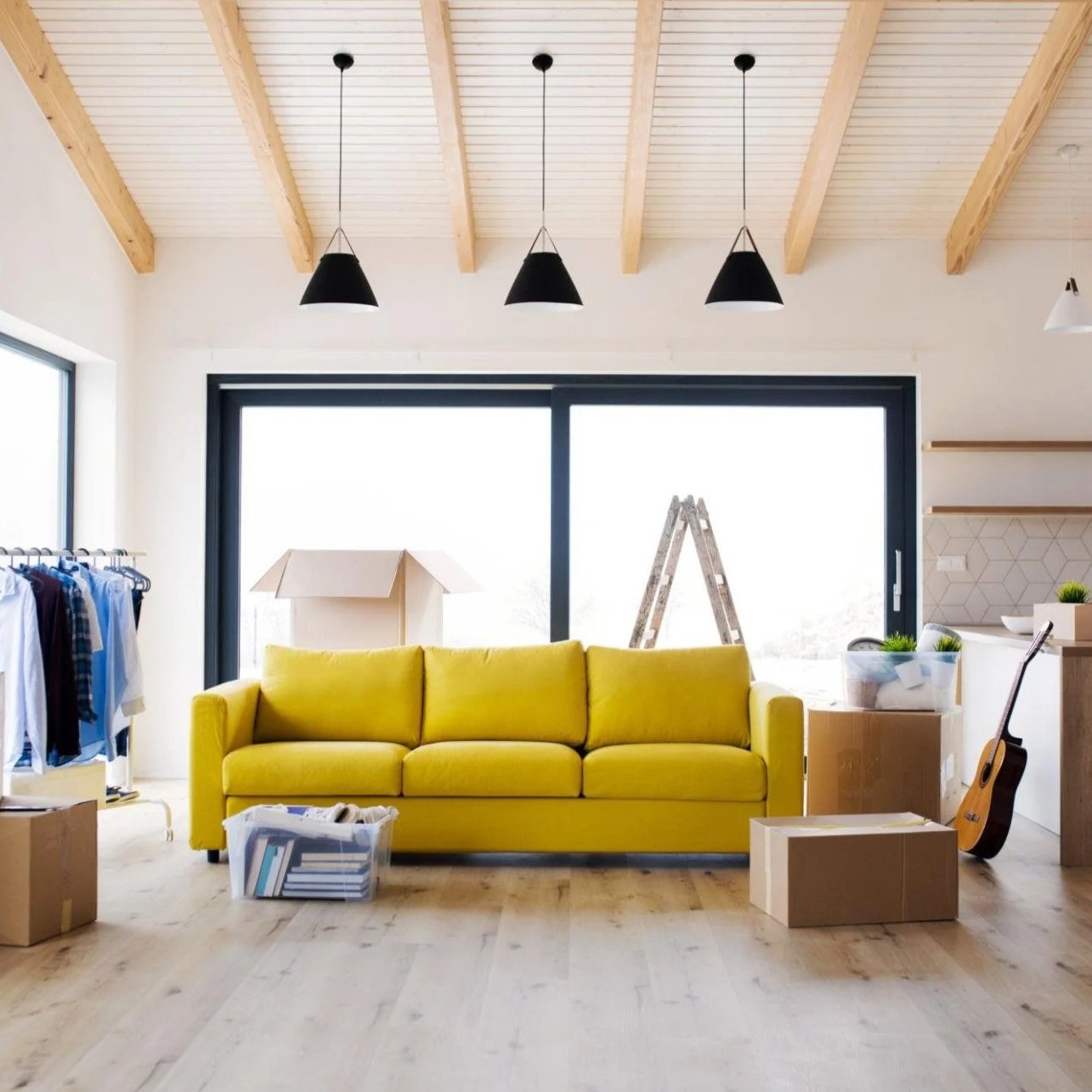 Bright living room with a yellow sofa and moving boxes ready to be unpacked.