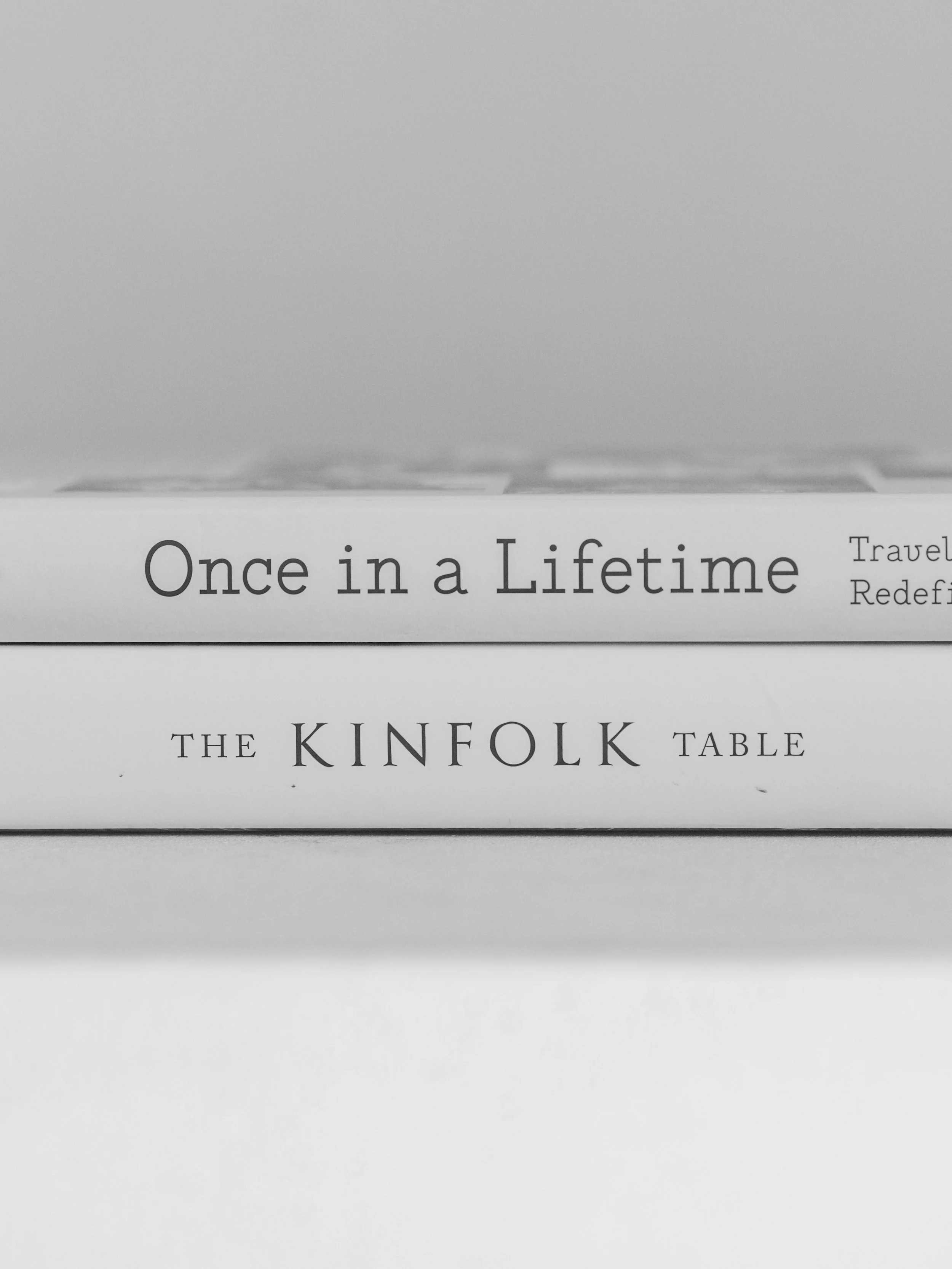 Book titled 'Once in a Lifetime' by The Kinfolk Table, with additional text 'Travel Redef...' visible on the cover.