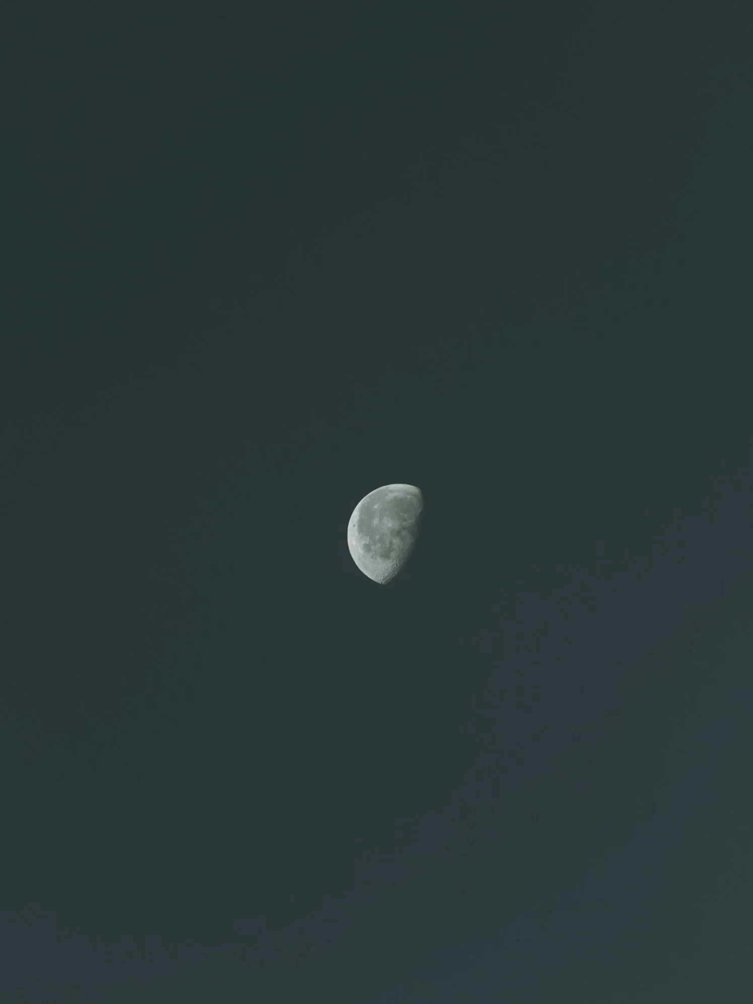 Crescent moon in the night sky with a dark background.