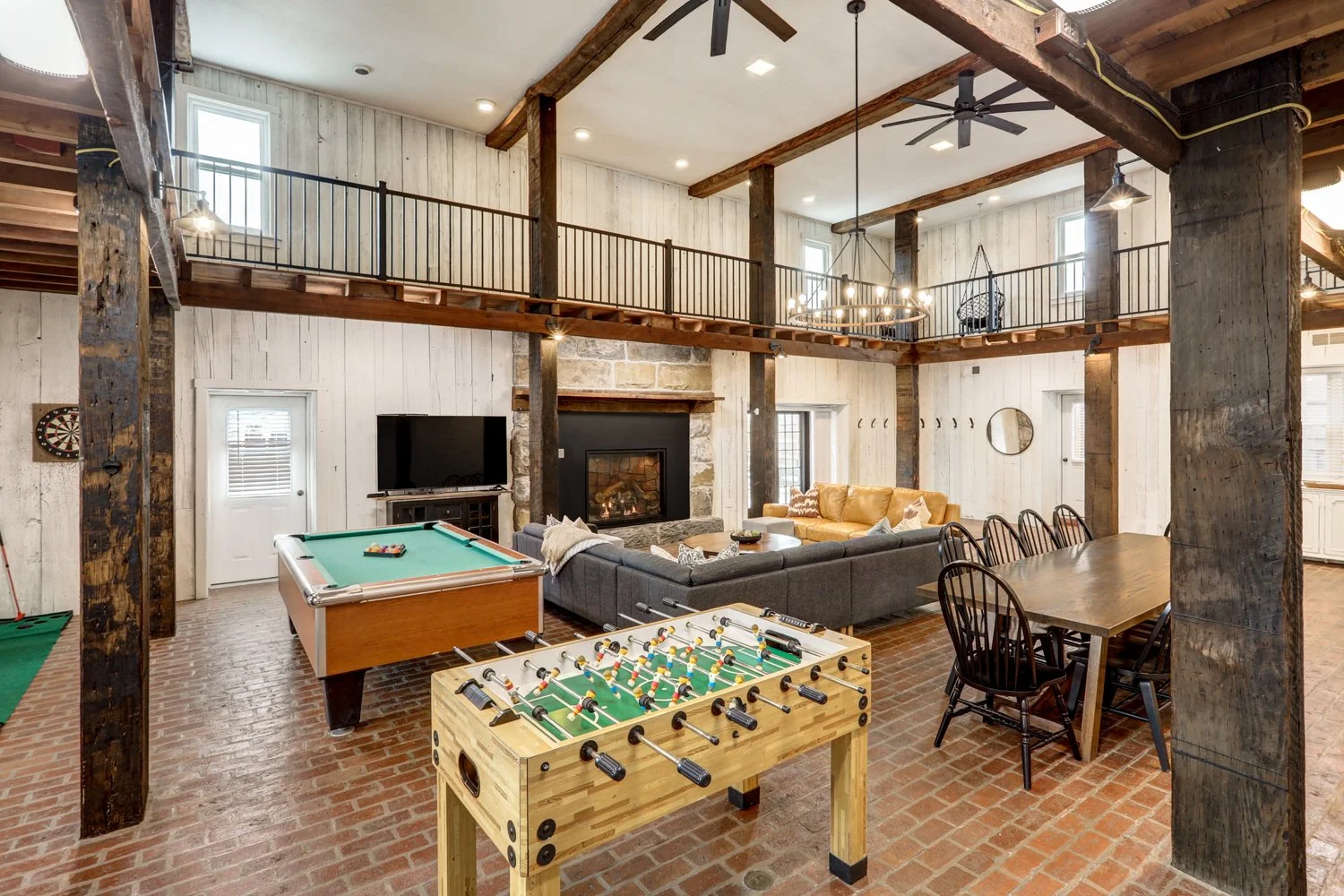 Game room area with pool table, foosball table, dart board, putterball game, Infinity game table, and record player. 