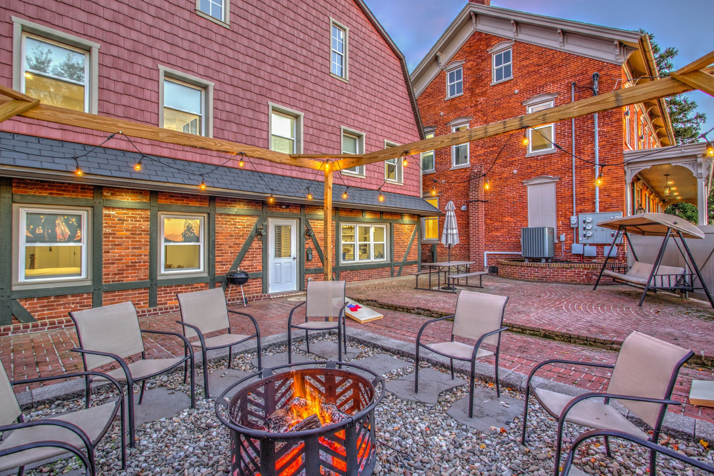 Brick courtyard with wood pellet grill/smoker, fire pit, and charcoal grill. Firewood, wood pellets, charcoal, and grilling supplies are provided. 