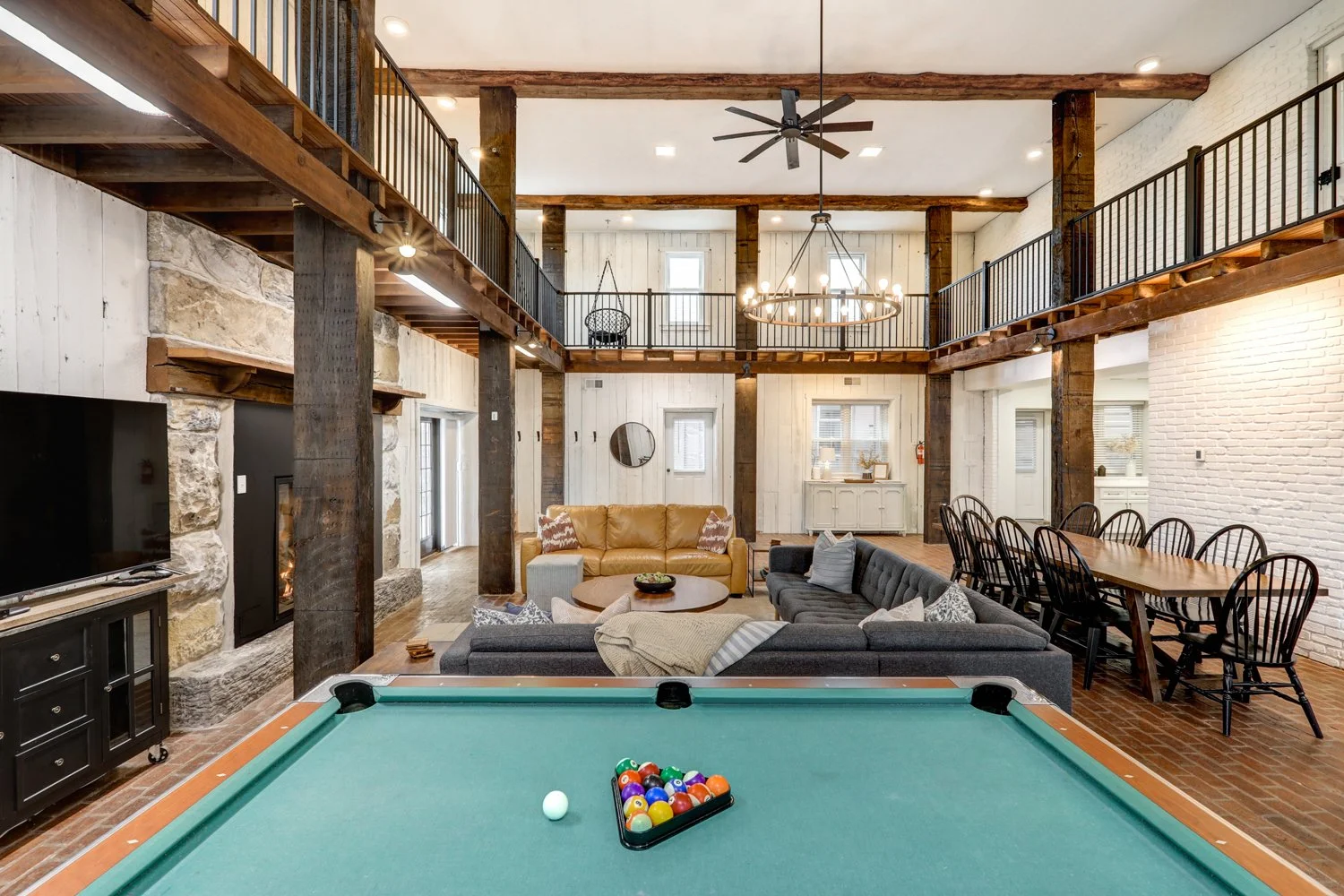 Game room area with pool table, foosball table, dart board, putterball game, Infinity game table, and record player. 