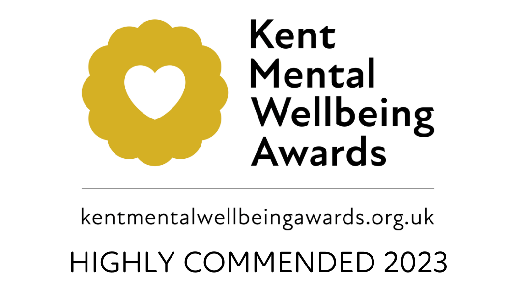 Logo for the Kent Mental Wellbeing Awards featuring a gold flower with a heart-shaped cutout, the award name in bold black text, website URL, and a note indicating 'Highly Commended 2023'.