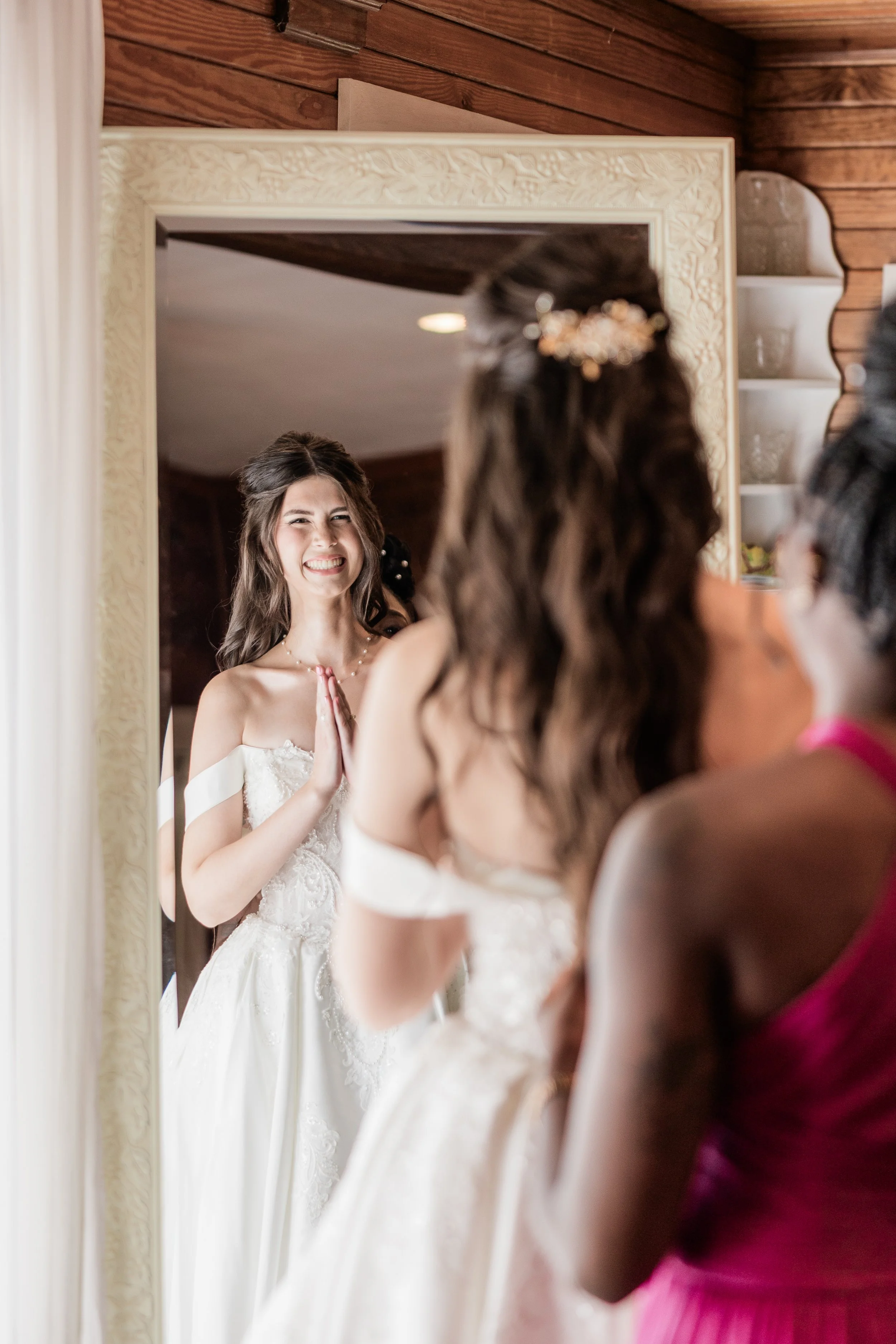 Bride smiling at her reflection, bridal hair and makeup by Briar & Bleu