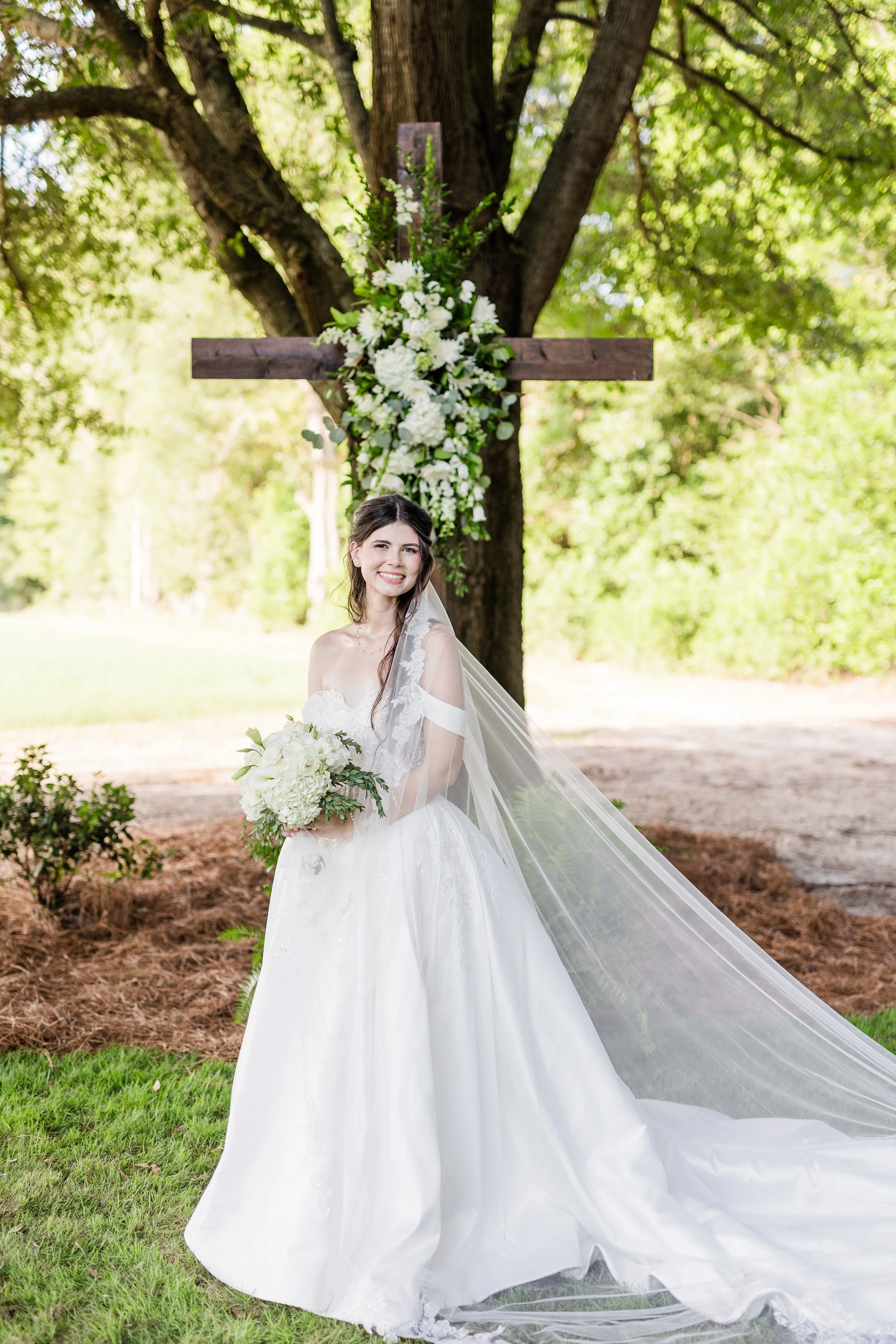 Bride with white bouquet beneath a tree, bridal hair and makeup by Briar & Bleu