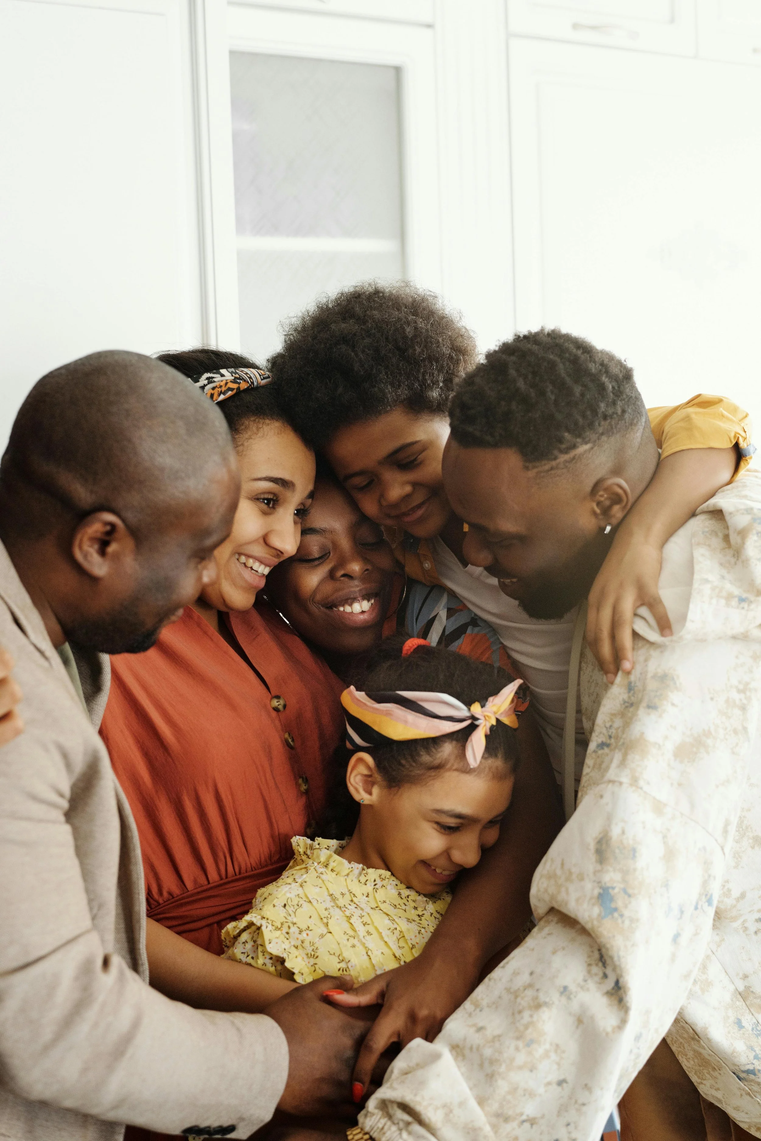 zoomed in photo of a family softly smiling and embracing each other